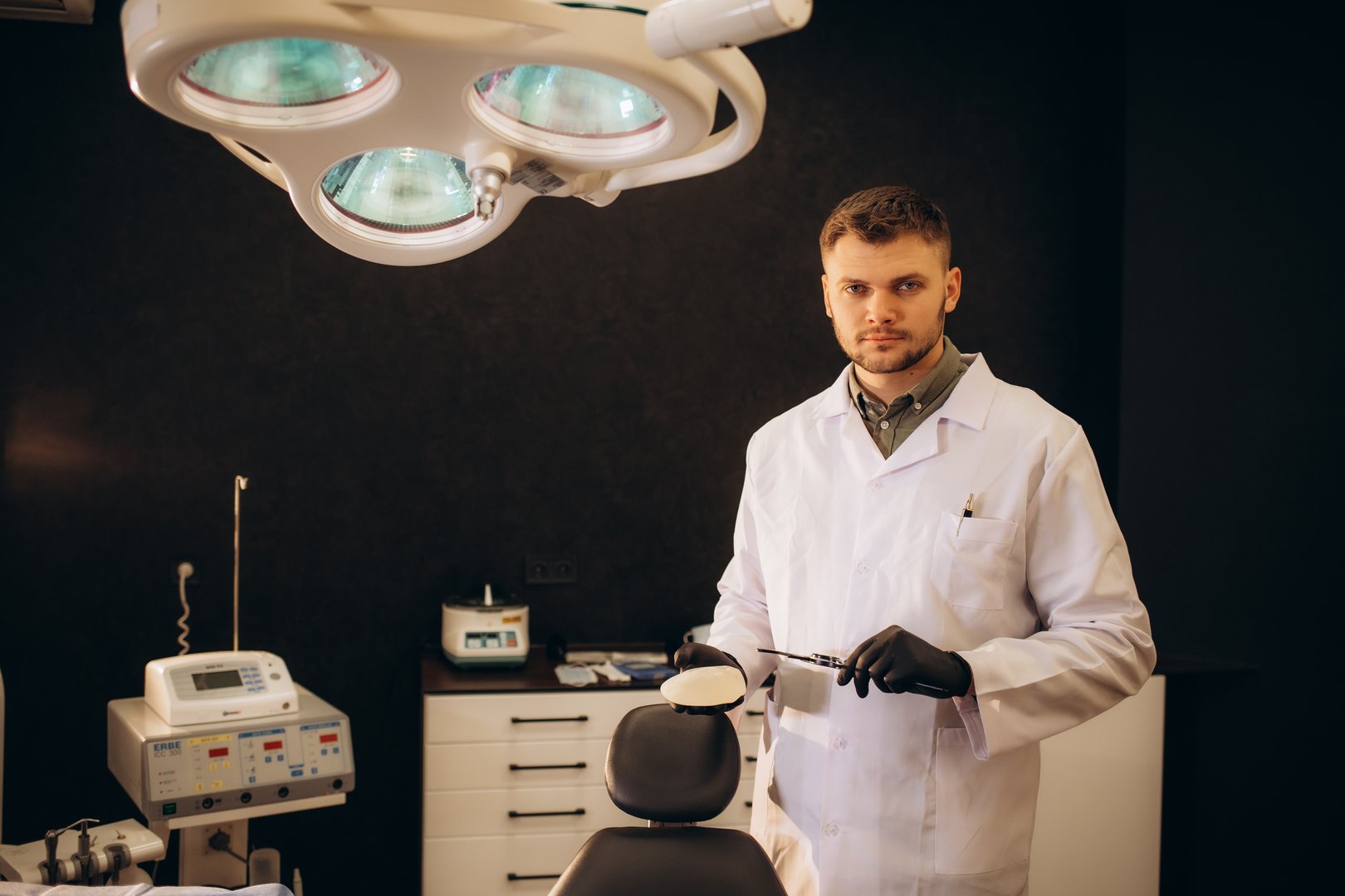 Doctor holding silicone implant for breast augmentation, space for text. Portrait surgeon holding silicone breast implants. Cosmetic surgery