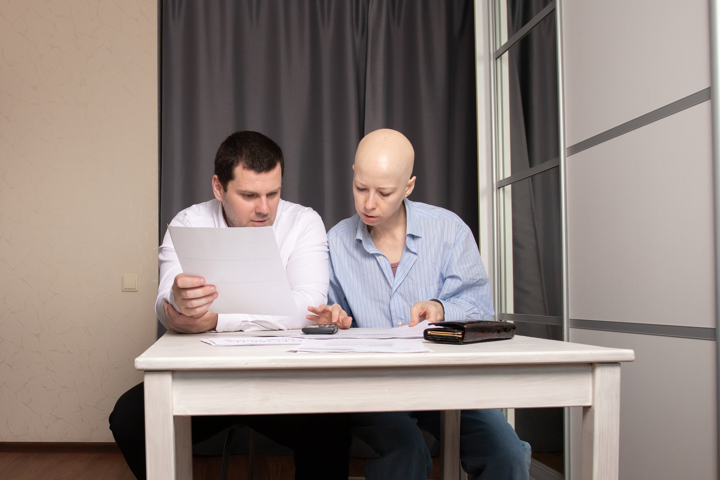 Man and woman sitting at table with documents, calculating bills and income, concept of financial problems, family expenses and debt management at home