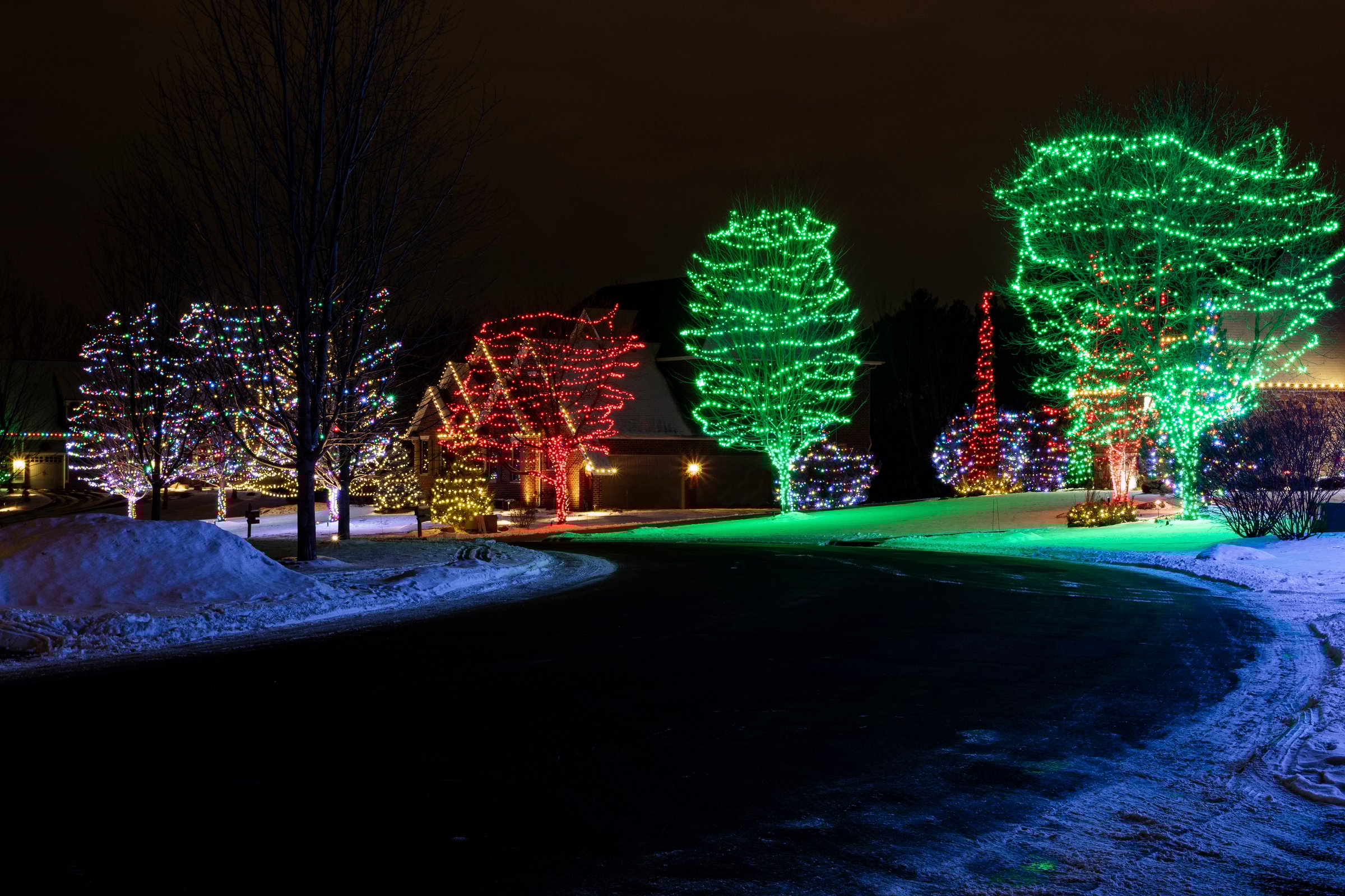 colorful holiday lights illuminate residential neighborhood