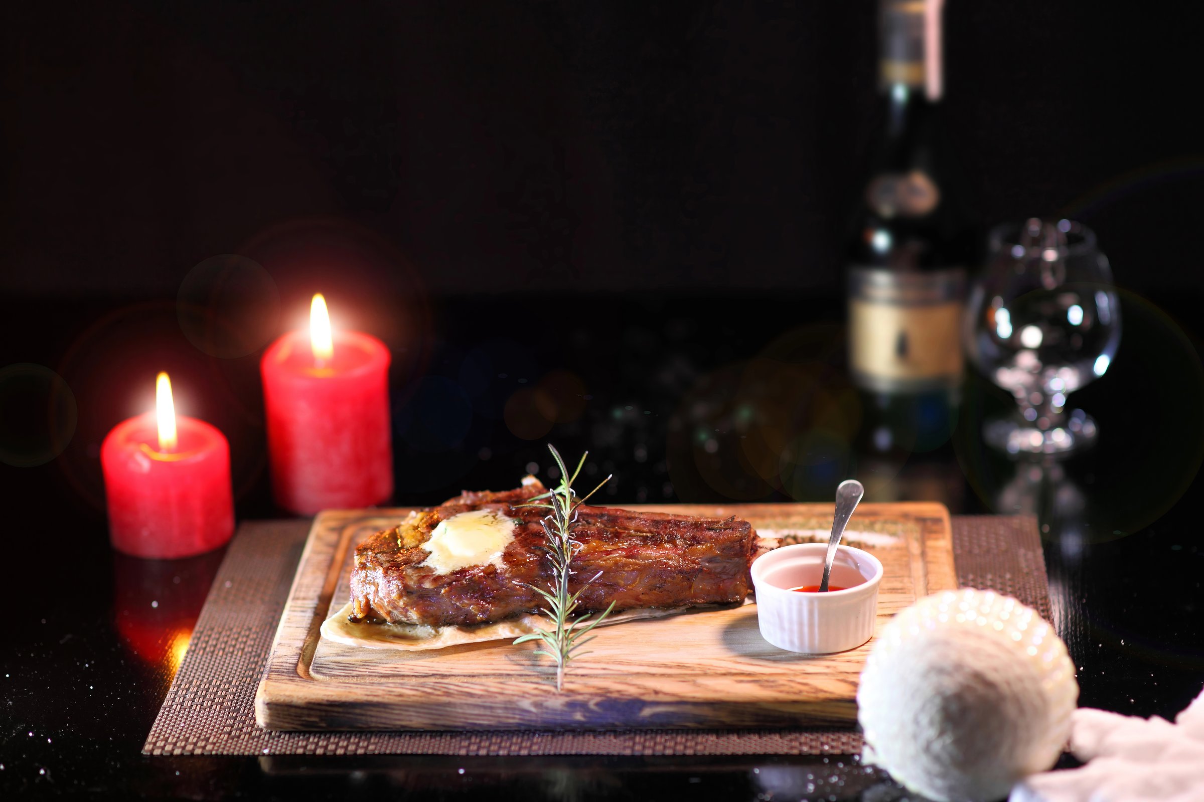 Christmas steak by candlelight. Christmas atmosphere and the mood to eat delicious steaks. Beef steak on a wooden board. Christmas table and steak.