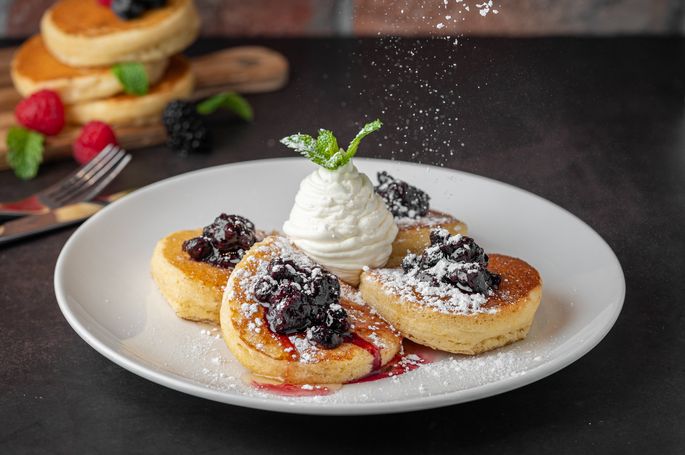 The fluffy pancakes topped with whipped cream and blackberries