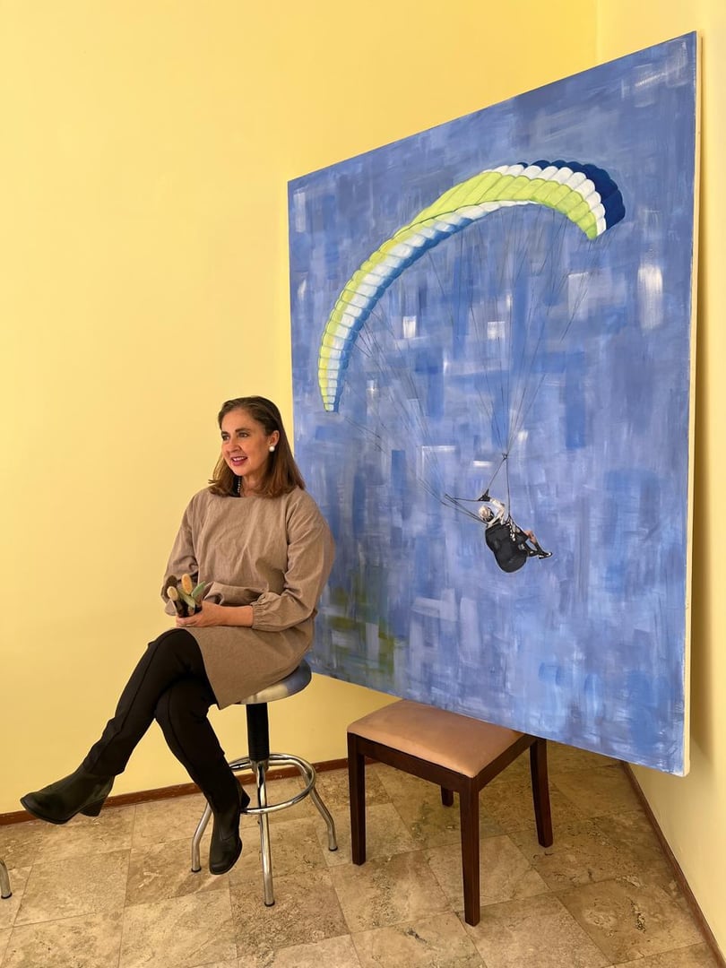Monica Meza en su estudio con pinceles y pintura Aire de Libertad