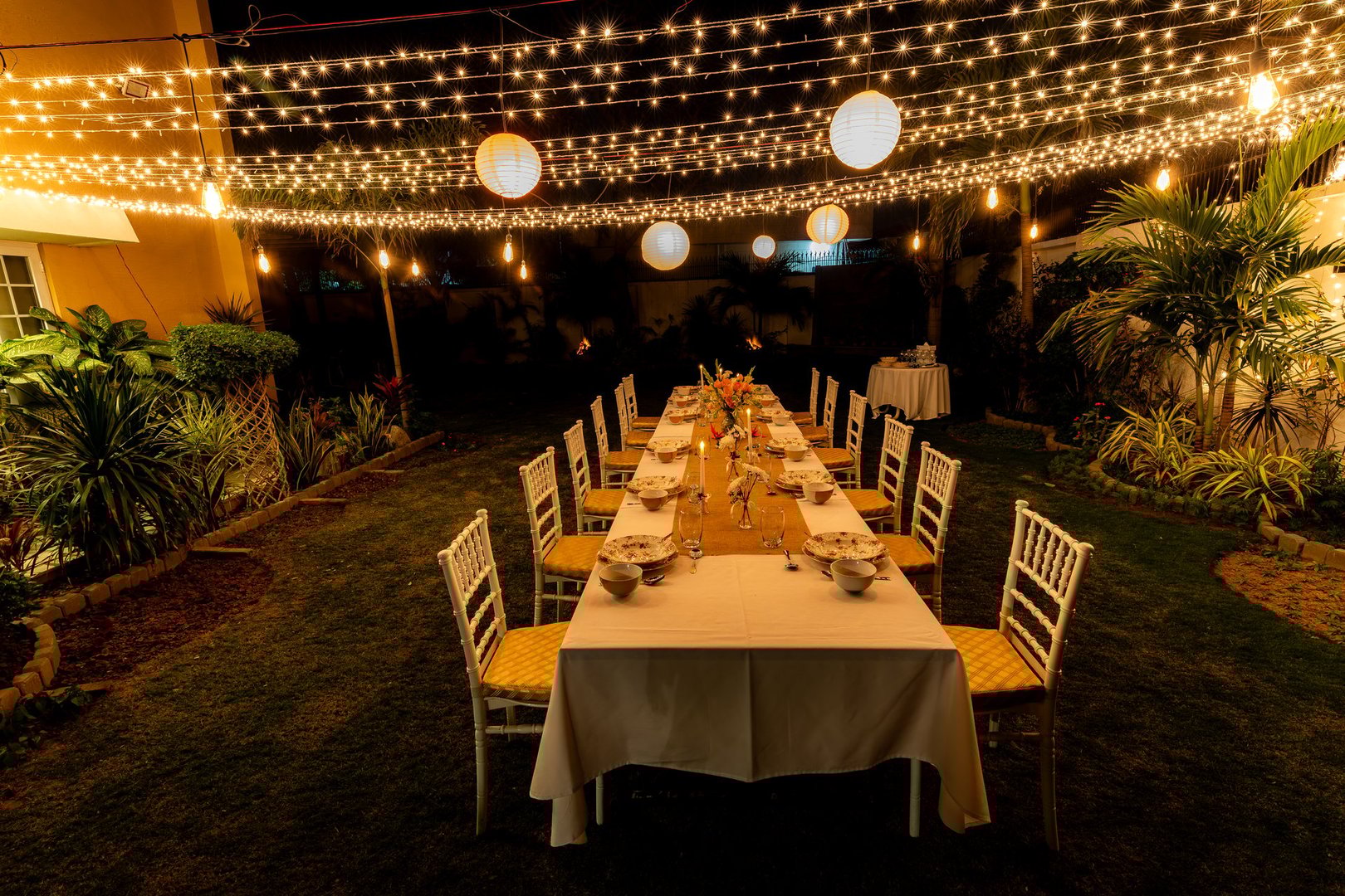 Summer winter candle light dinner party theme with fine dinning arrangements fairy lights and latrines in garden!
