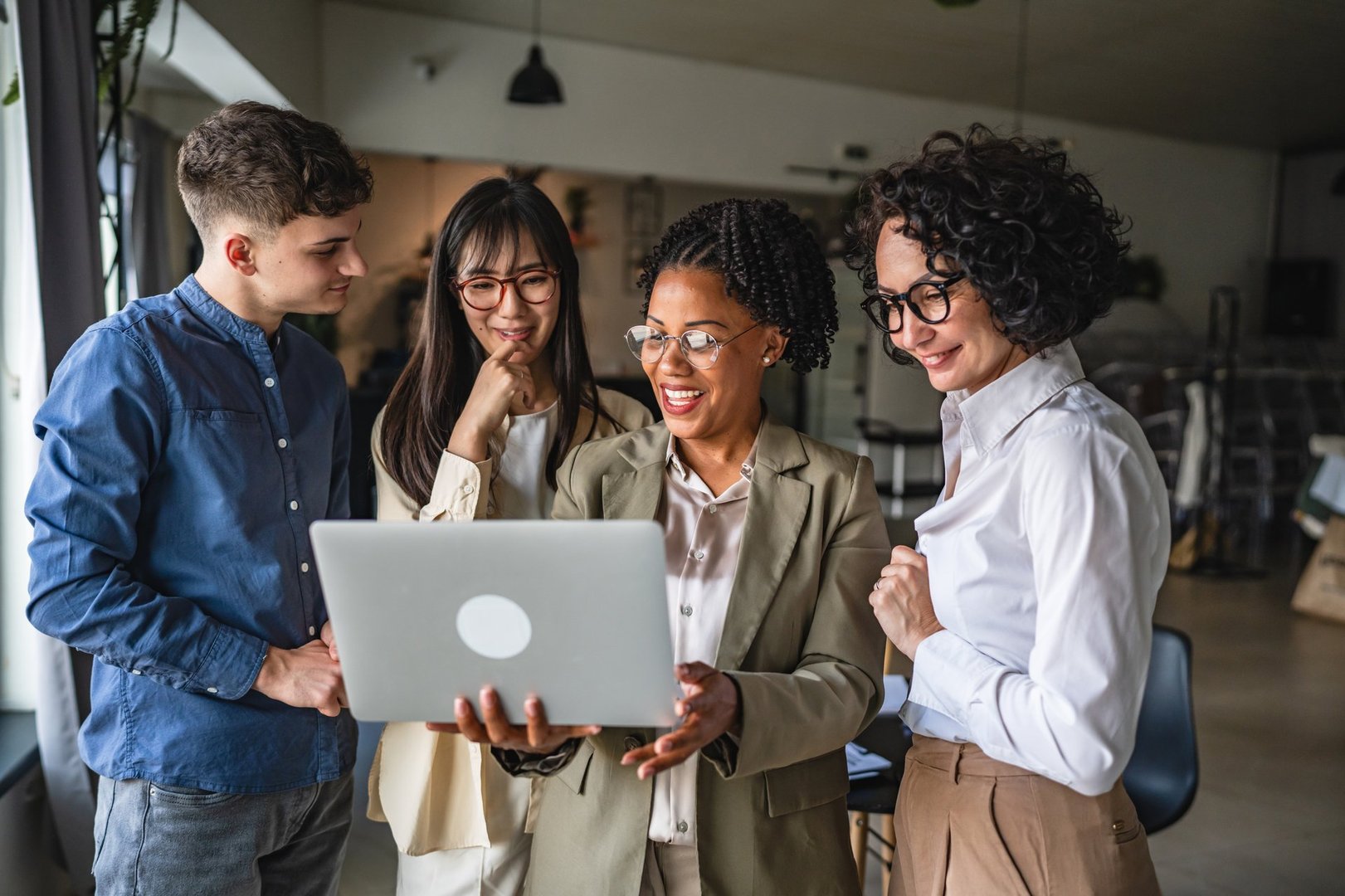 multicultural business people use laptop for work on project together in office