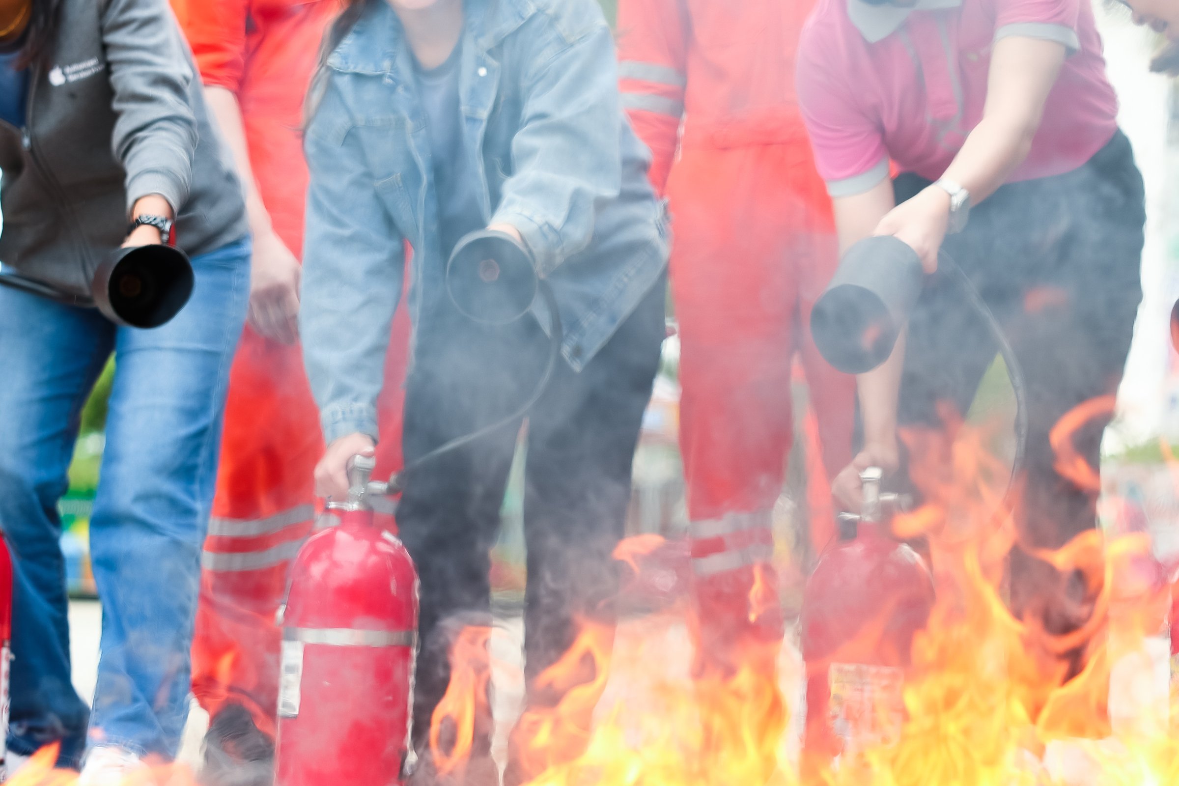 Employees firefighting training, Concept Employees hand using fire extinguisher fighting fire closeup