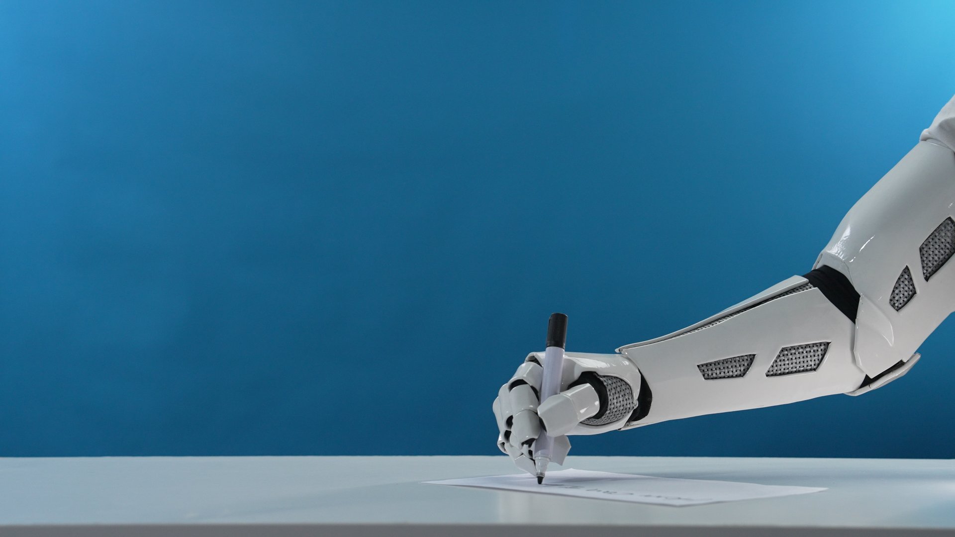 A robotic arm elegantly holds a pen and writes on a sheet of white paper. The vibrant blue background enhances the futuristic theme of technology and automation.