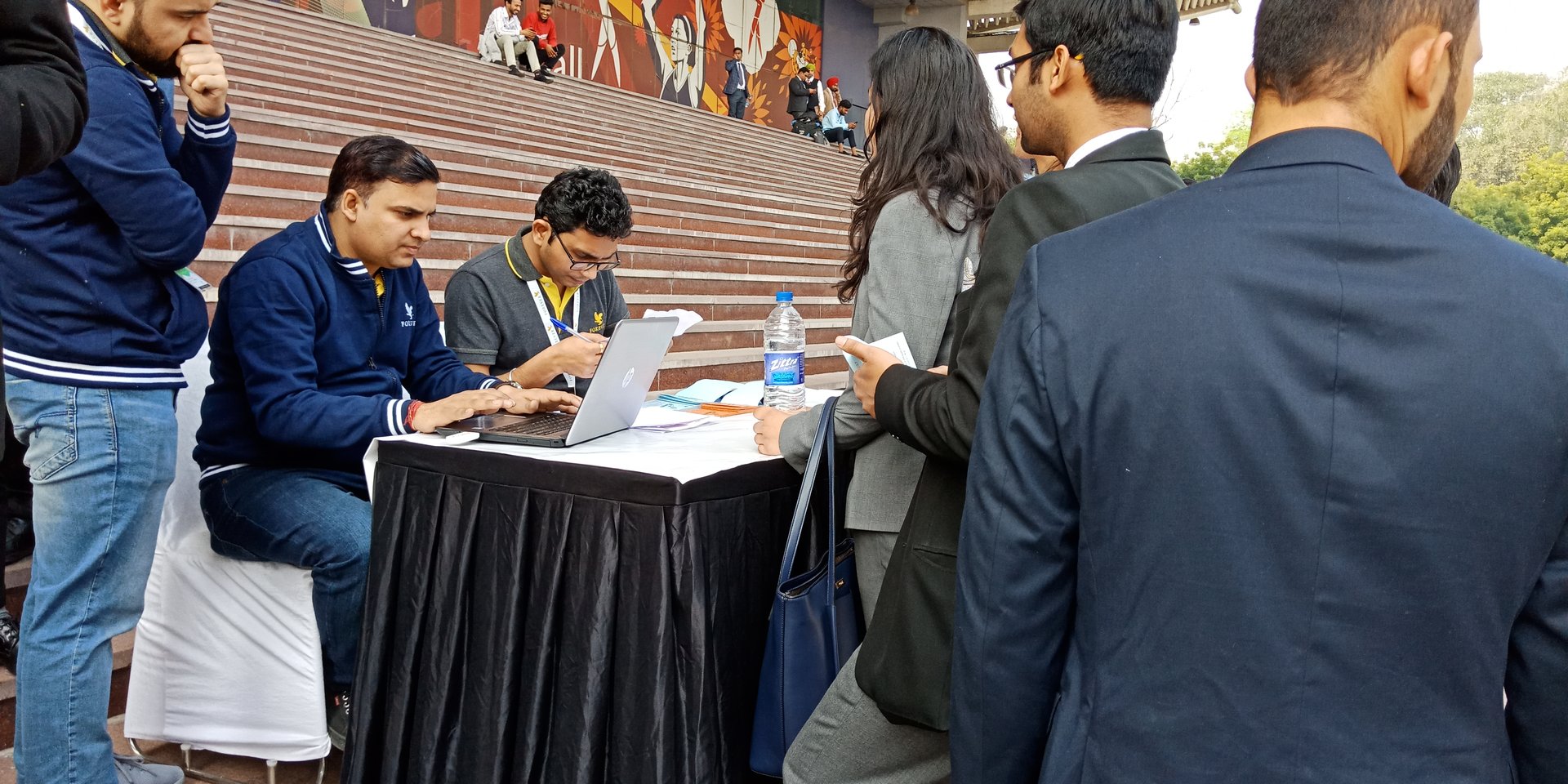 Indian people collecting entry ticket from cash counter for company annual conference at Thyagaraj Sports Complex in delhi.