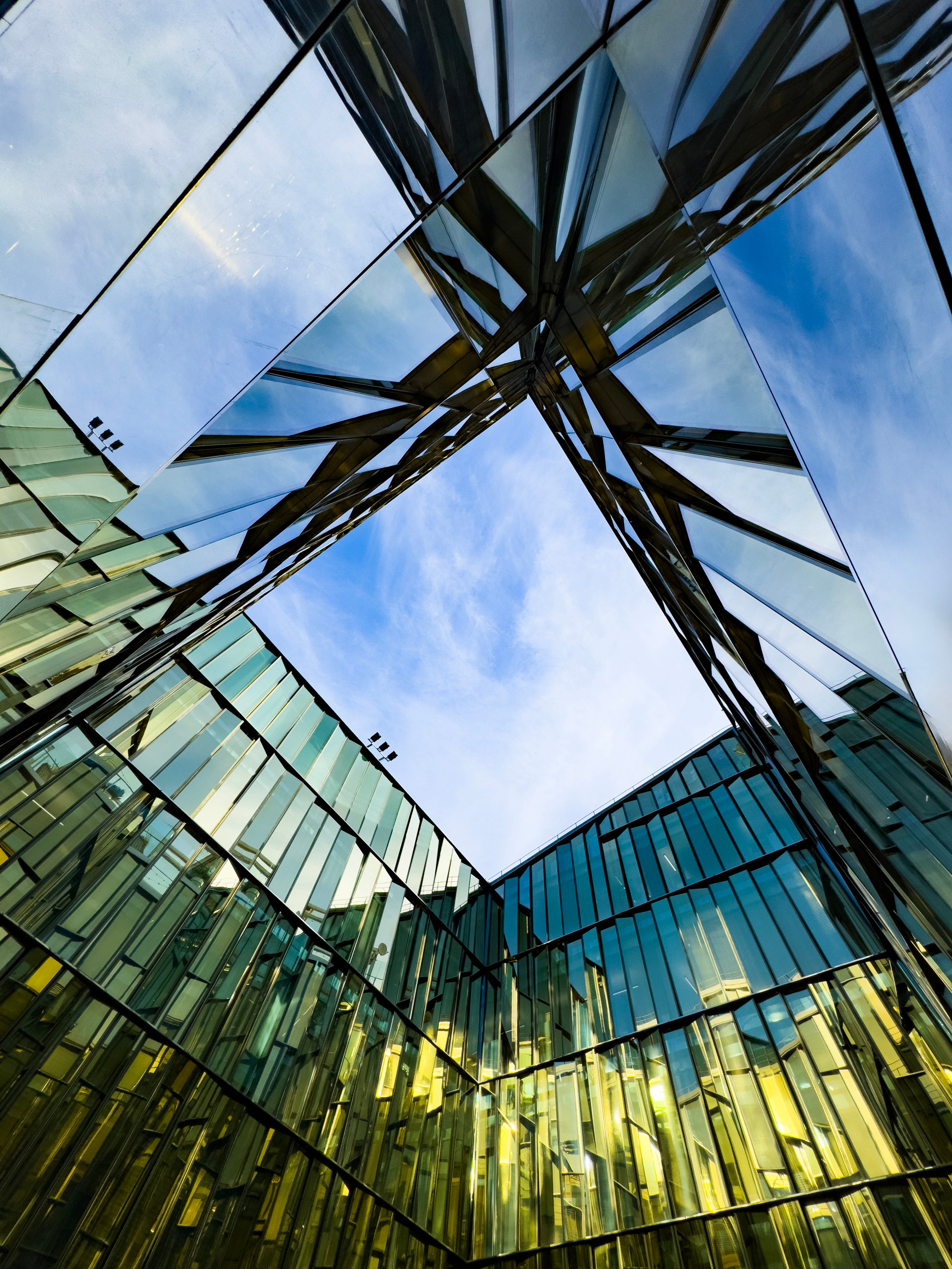 Stunning view of contemporary glass building exterior with clear blue sky reflection