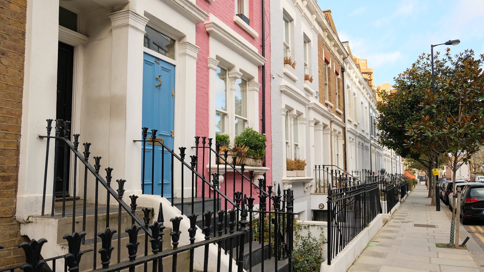 Typical Victorian terraced houses in England. Exterior view of cozy residential buildings in London with metal fence, several floors, windows and front door with molding. Real estate, Living apartments.
