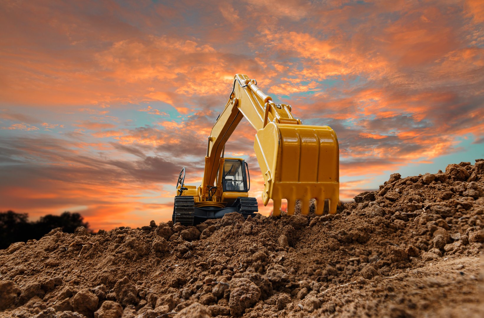 Crawler excavator with are digging the soil in the construction site on the sunset  backgrounds