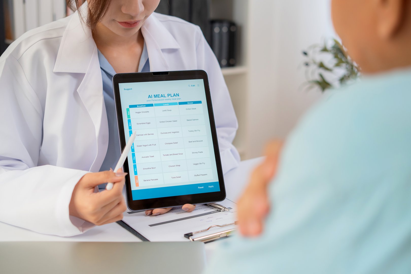 Asian nutritionist using tablet to explaining personalized meal plan with AI to patient during healthcare consultation, healthy lifestyle, woman dietitian showing nutrition plan with AI on tablet.