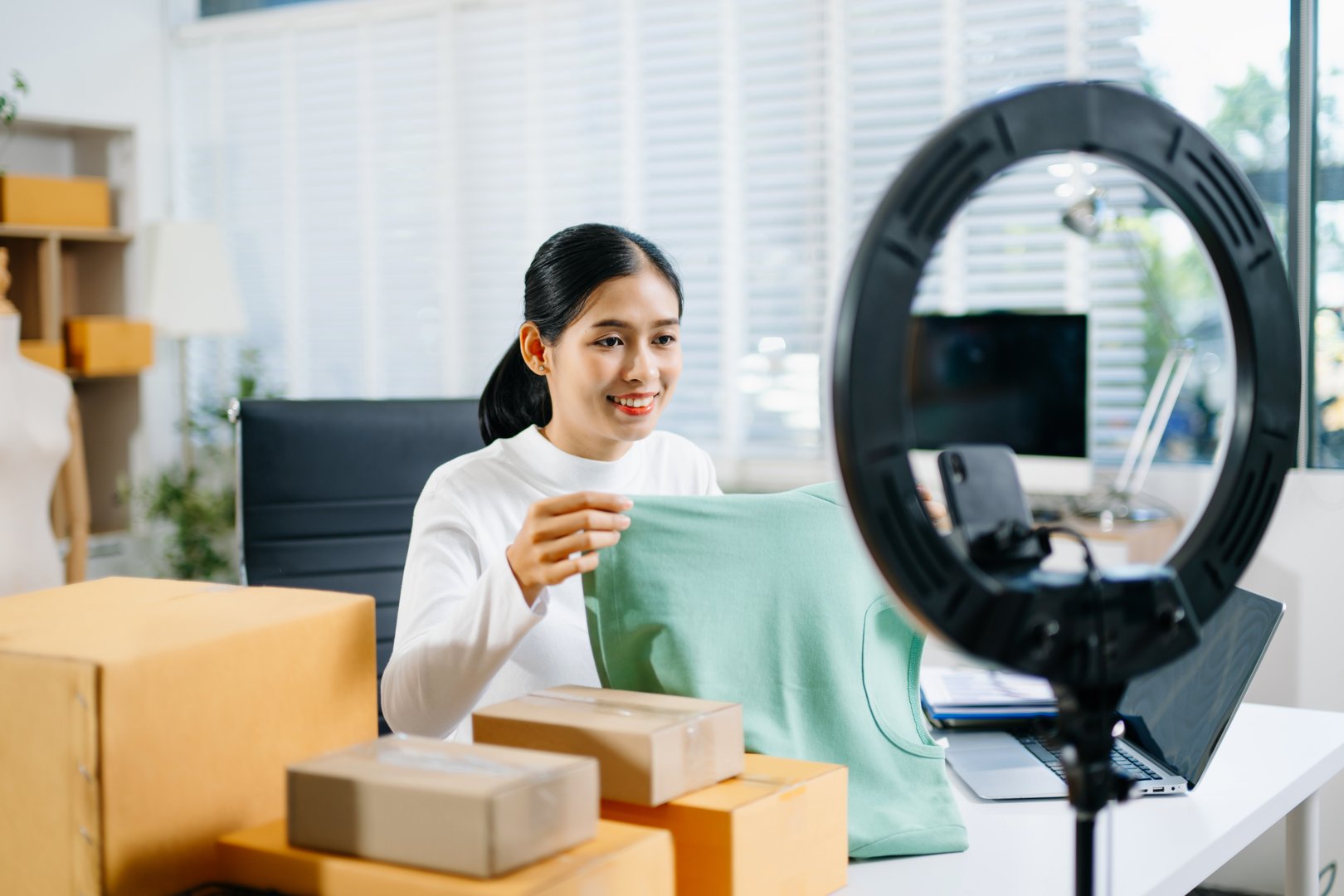 Fashion blogger concept, Young Asian women selling clothes on video streaming.Startup small business SME, using smartphone or tablet taking receive and checking