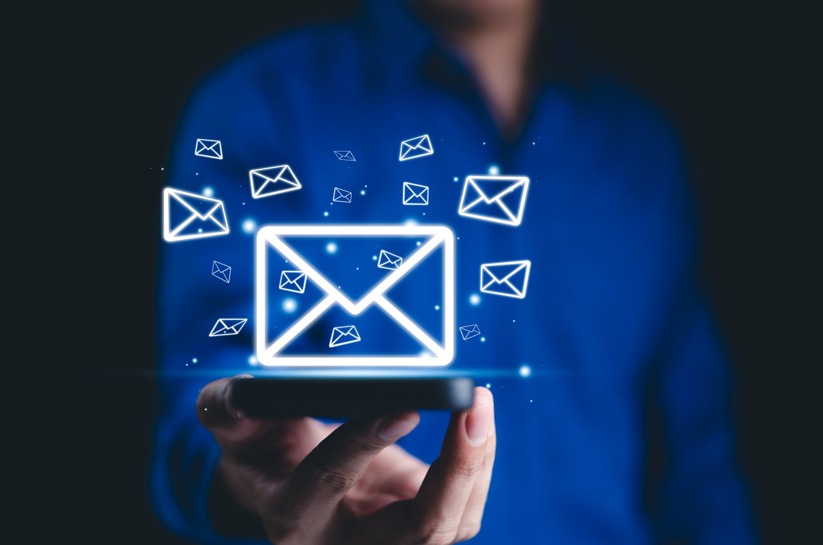 New email notification, online communication concept. A person holds smartphone with multiple glowing envelope icons floating, email notifications, and digital messaging. connectivity, eIectronic mail