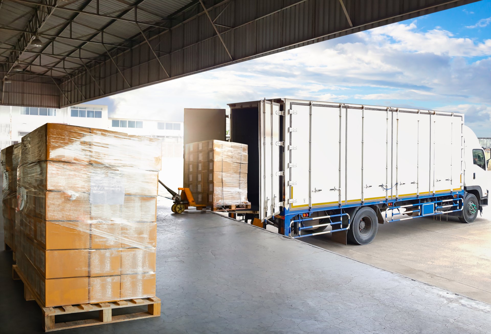 Container trucks parked loading pallets at warehouse dock