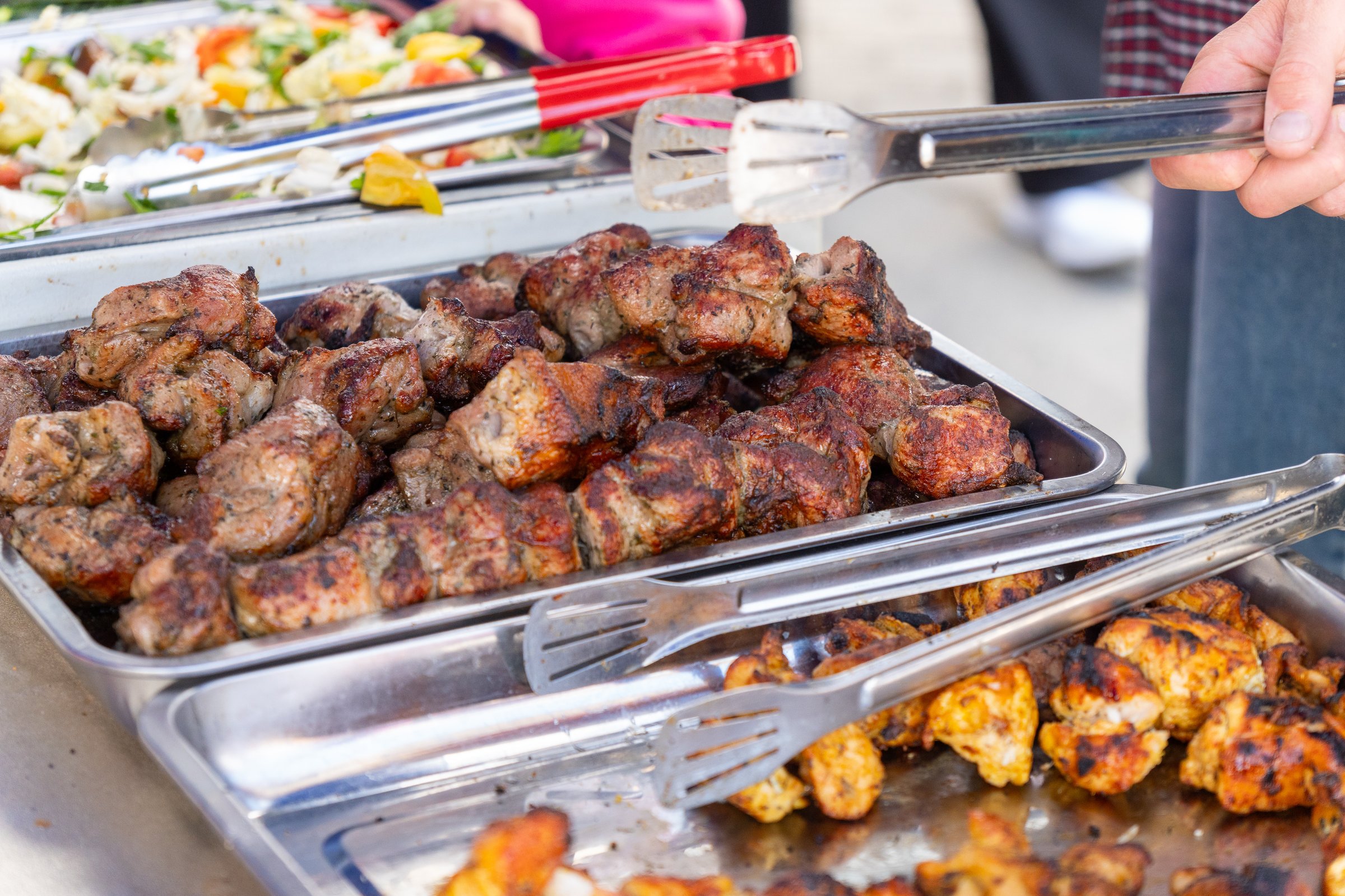 Metal trays with aromatic roasted kebab in a street food cafe , ready to serve.