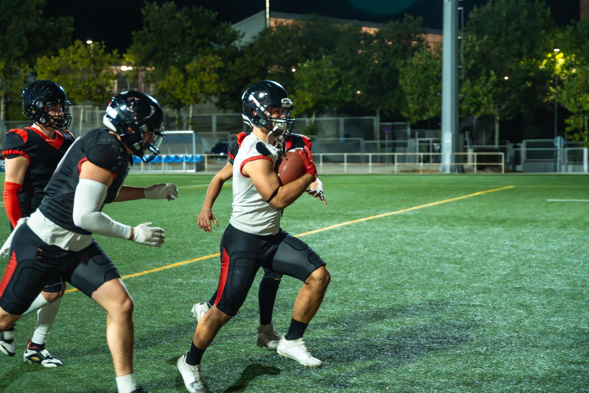 Football player running under stadium lights