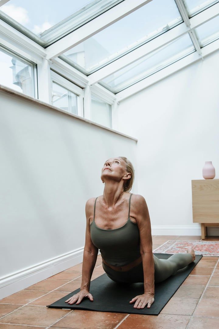 Group of young sporty people practicing yoga lesson with instructor, stretching in Bending Side Plank exercise, Vasisthasana pose, working out, indoor studio image. Wellbeing, wellness concept