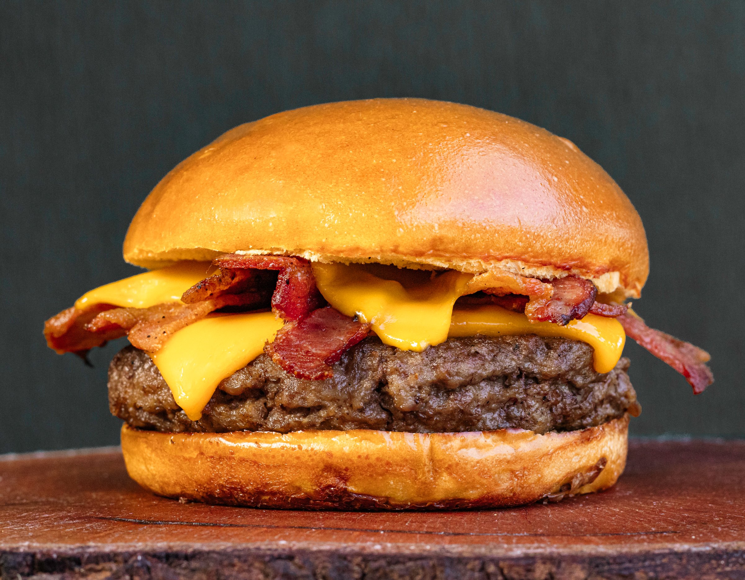 classic traditional burger meat cheese sun-dried beef on a neutral background on top of a wooden board