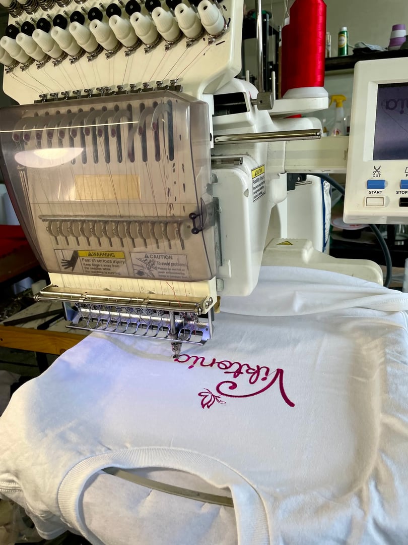 machine embroidery of a logo on a T-shirt with purple threads