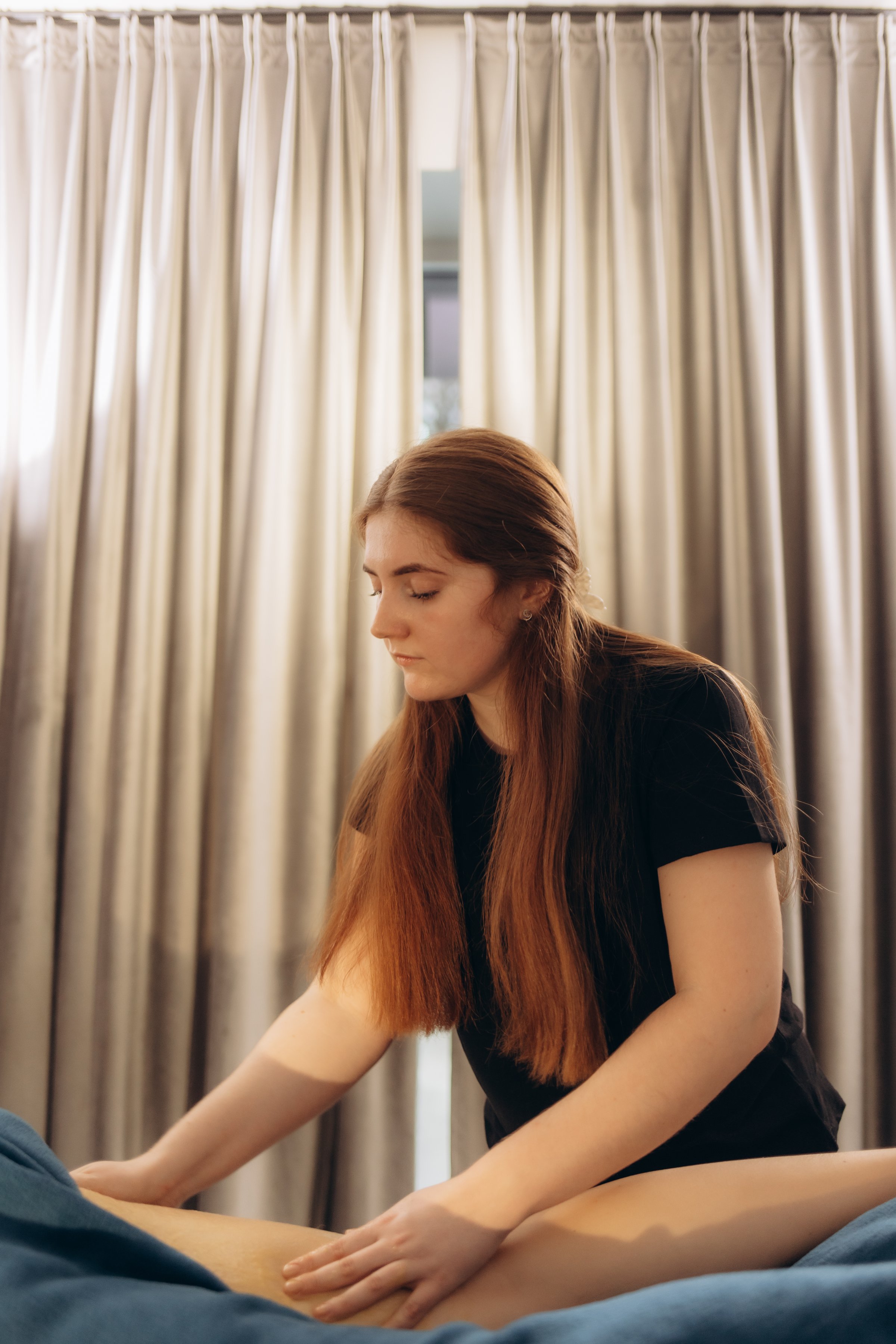 A masseuse performing a therapeutic massage in a serene room, fostering relaxation and wellness. Suitable for depictions of spa treatments, health care practices, and self-care activities.