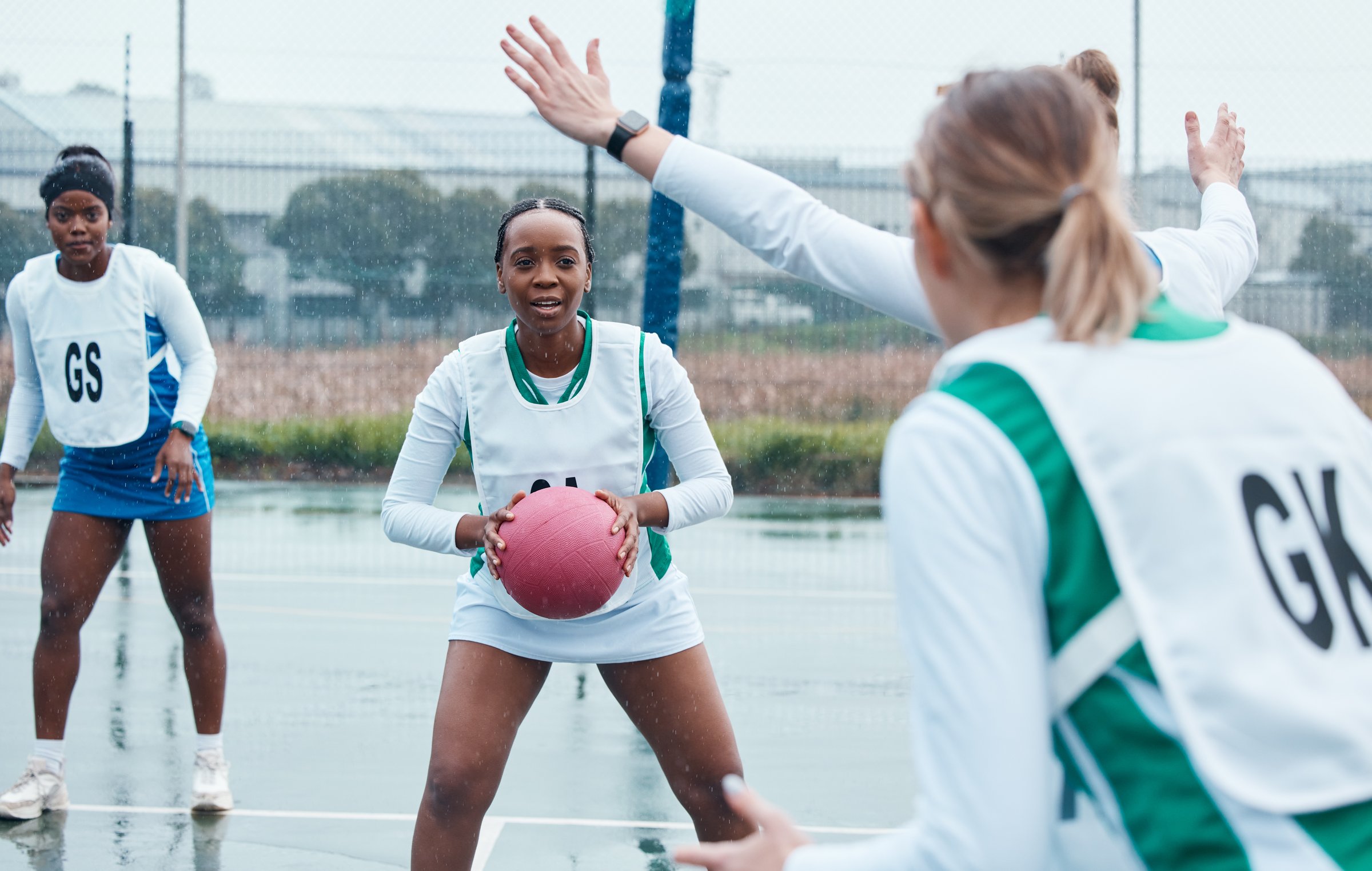 Netball sports team, ball and black woman in community competition, practice and play outdoor game. Fitness, collaboration or group workout, player tournament or African athlete training on wet court