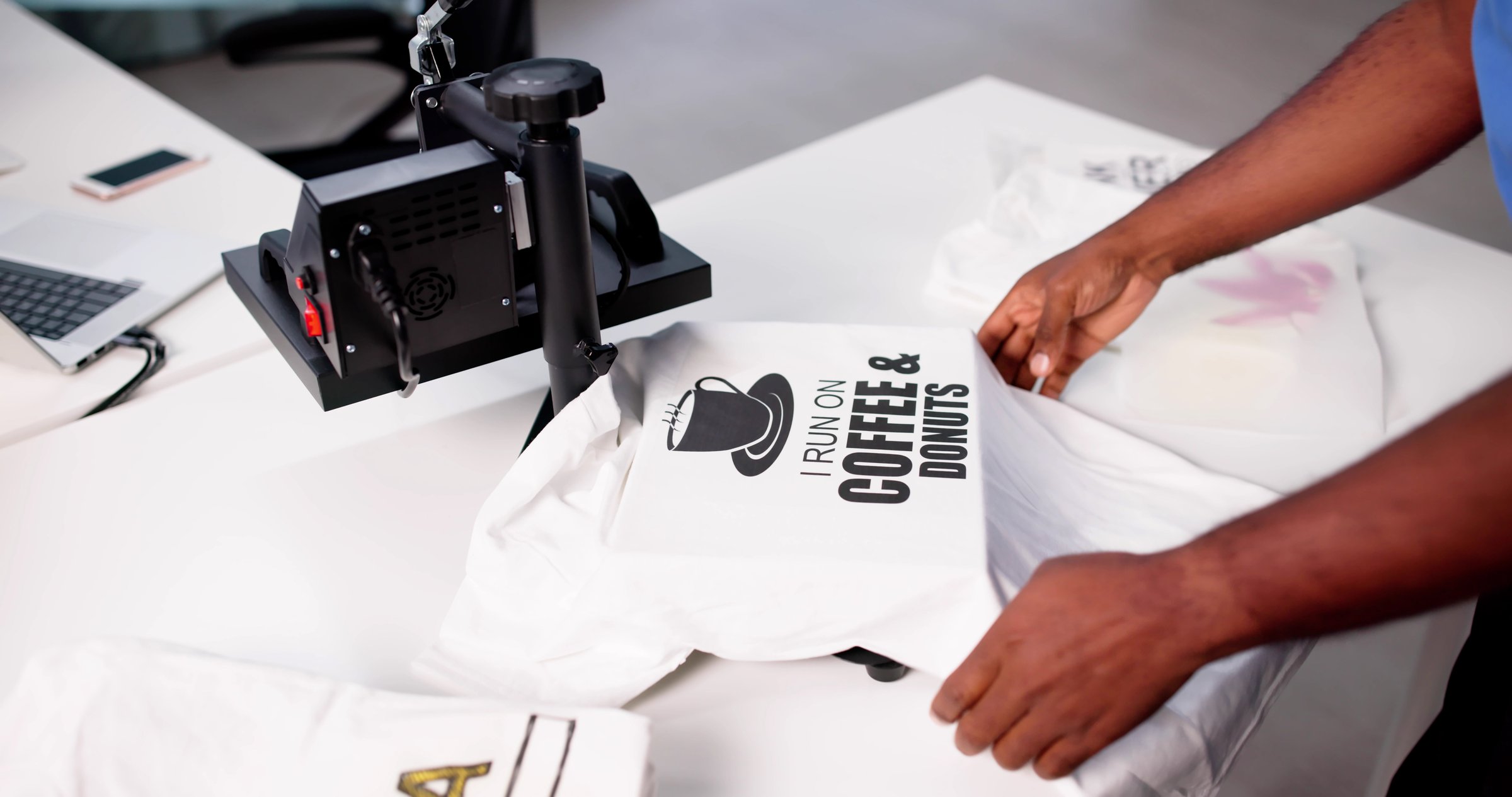 African-American Man Screen Prints Custom Logo T-shirt At Heat Press Factory.
