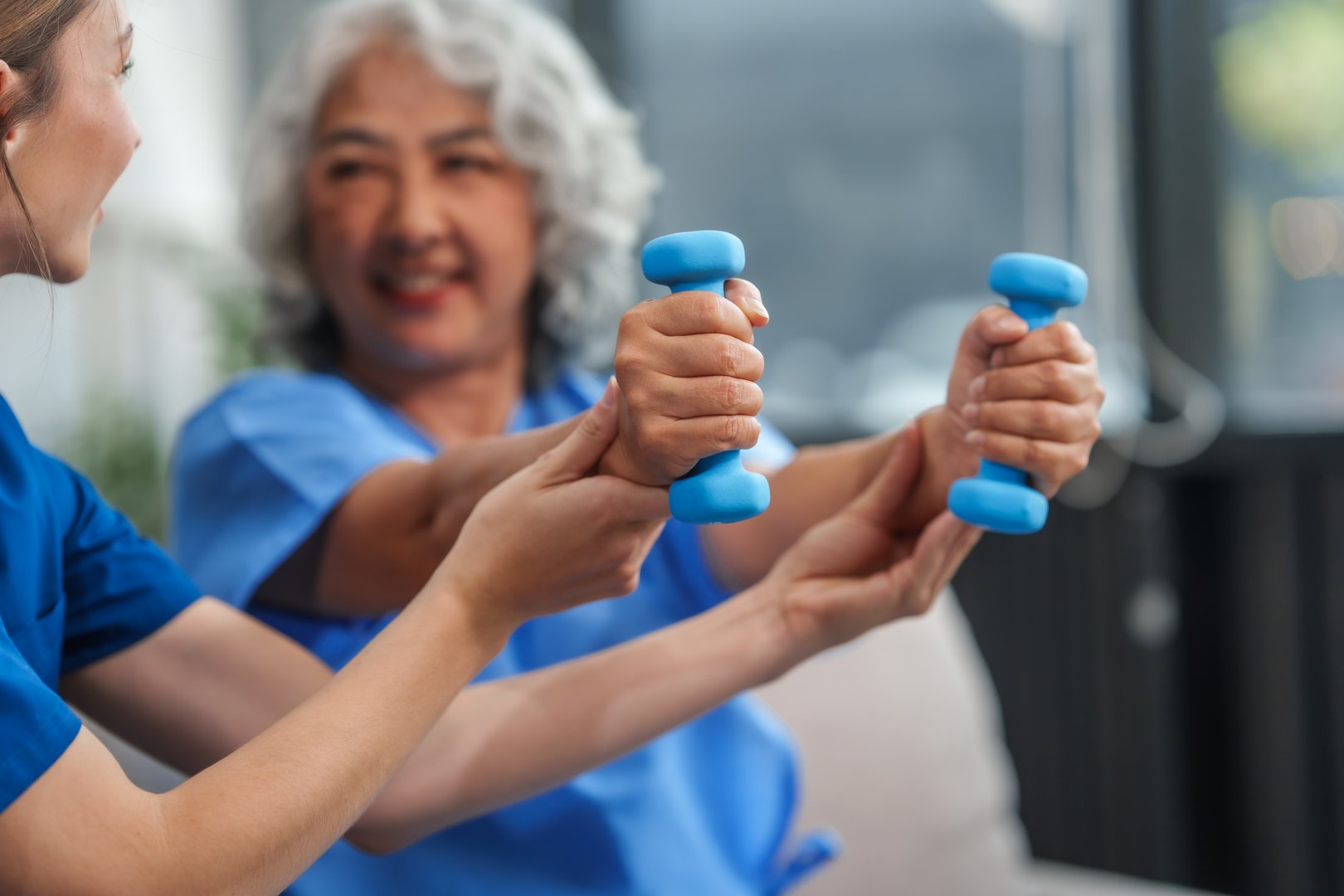 A young Caucasian physical therapist and an elderly Asian woman in her 60s attended a physical therapy course regarding muscle pain and muscle weakness. and heel pain with elastic bands