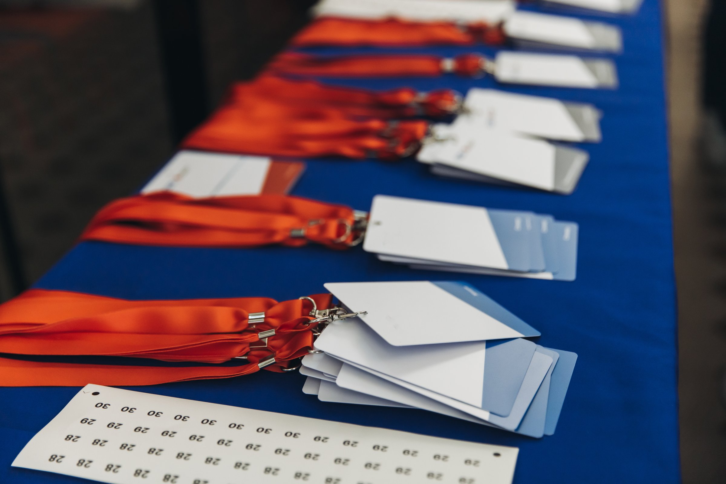 Process of checking in on conference congress forum event, registration desk table, visitors and attendees receiving lanyard with name badge and entry wristband bracelet and register electronic ticket