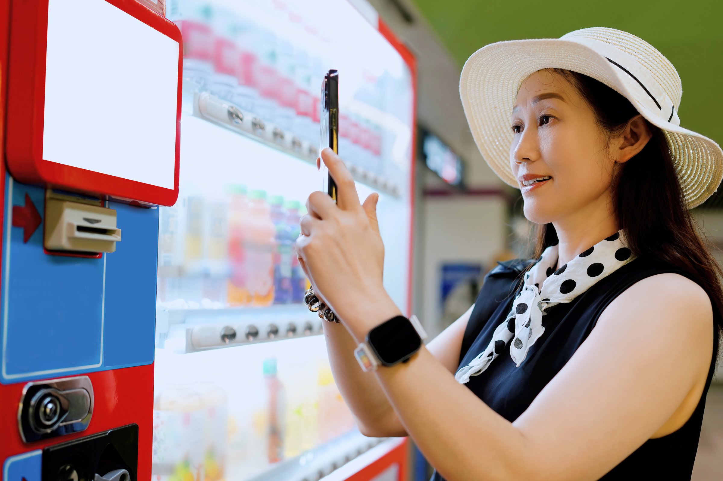 Capturing the Moment: Woman Using Smartphone by a Vending Machine