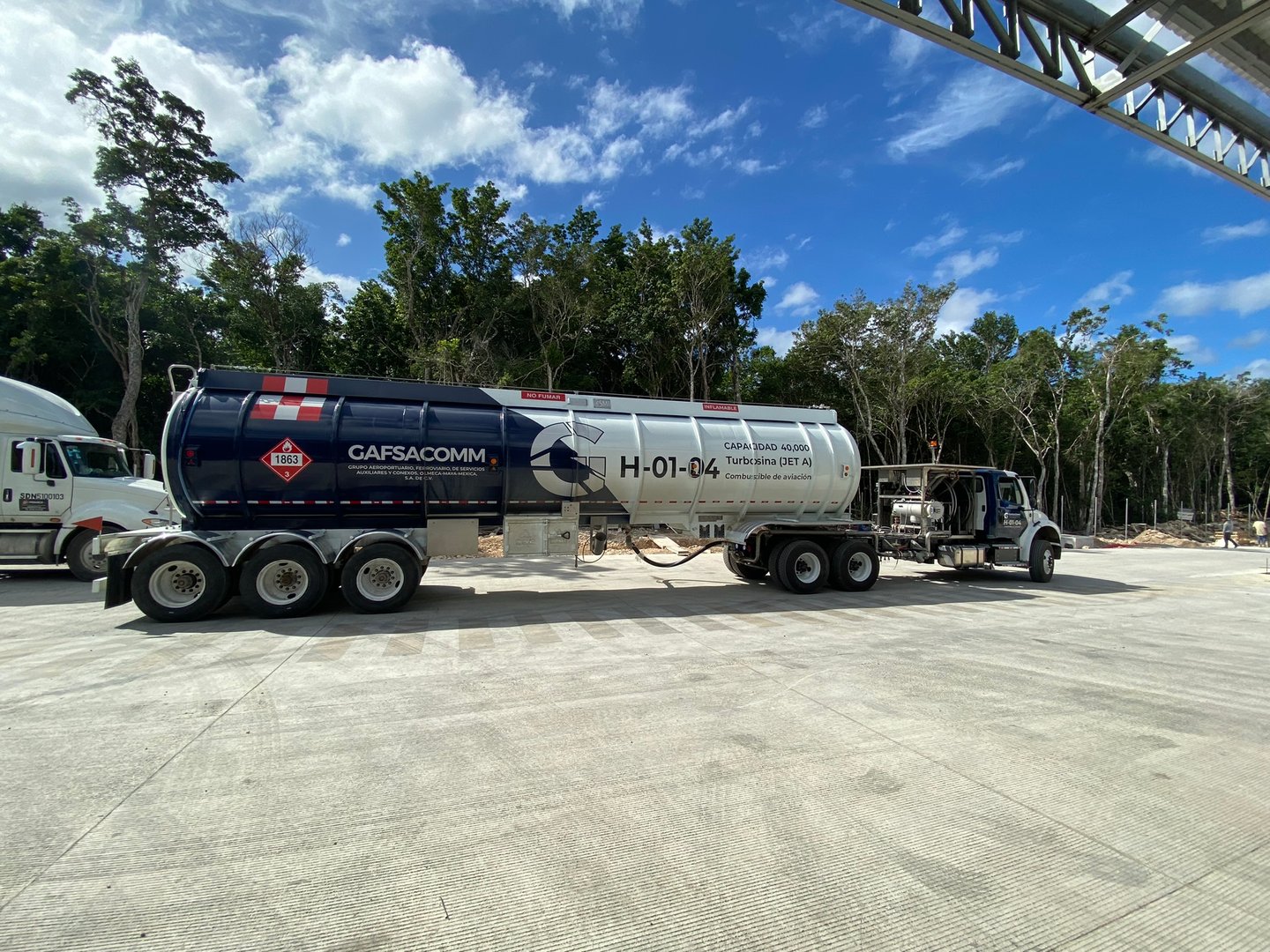 Large GAFSA fuel tanker truck parked on a concrete lot, surrounded by trees under a clear blue sky.