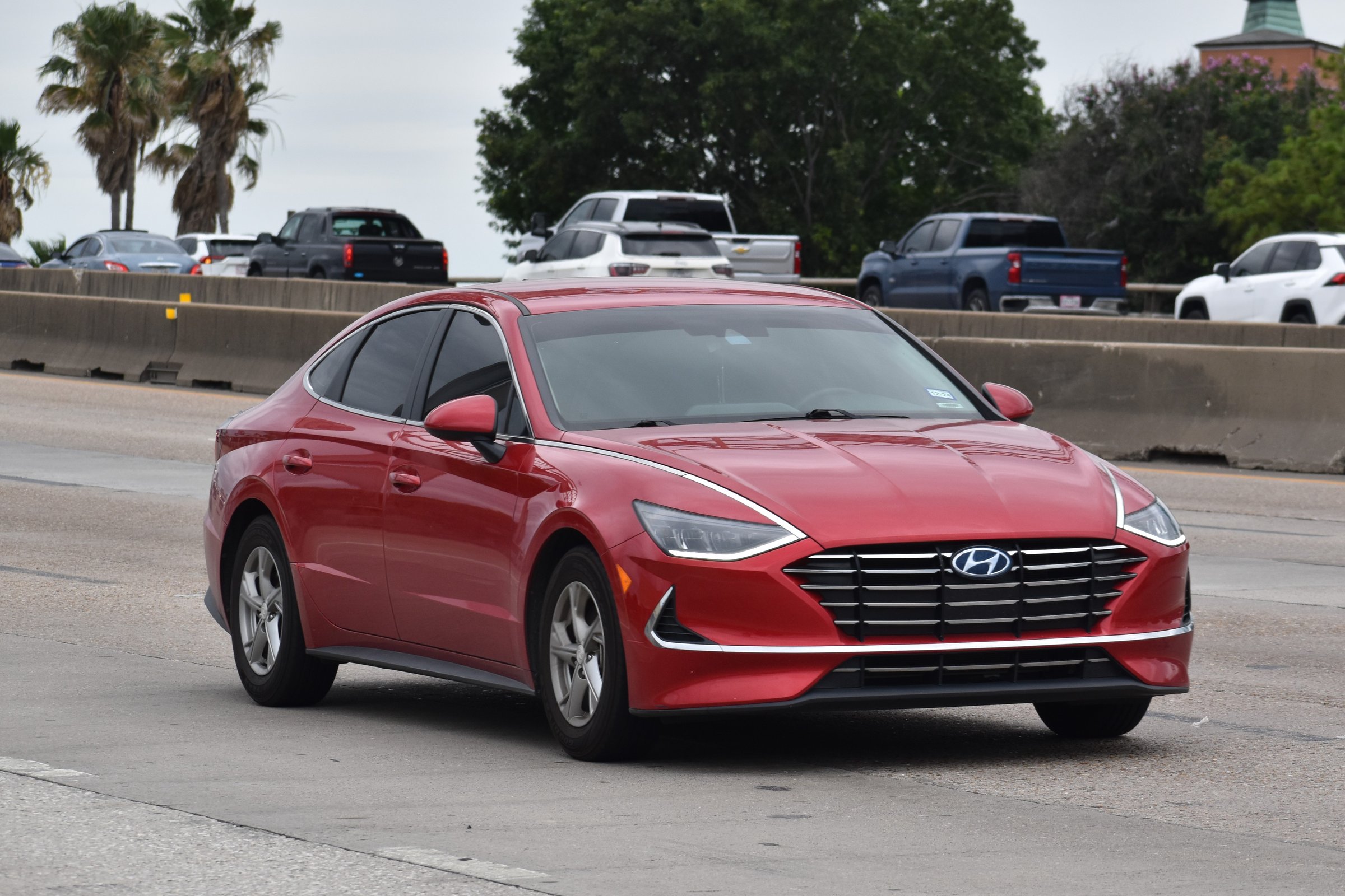 Houston, TX USA - 5/11/2024 - A portrait of a red Hyundai Sonata sedan traveling ahead of the competition on a highway in moderate traffic