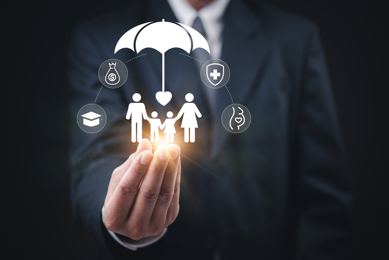 Businessman holding a glowing umbrella icon with a family protection concept, representing life, health, finance, and education insurance.