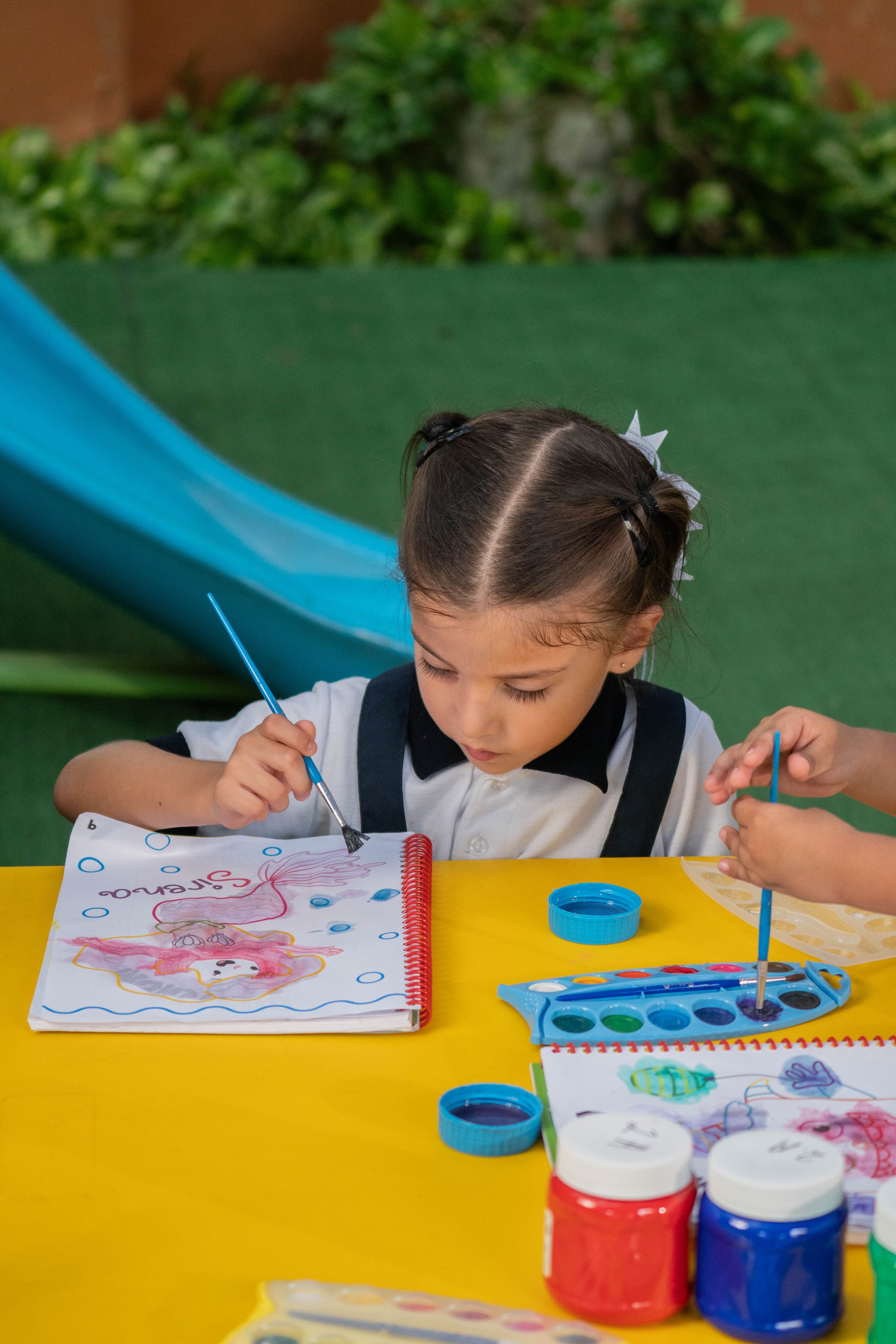 Niña pintando en el jardín