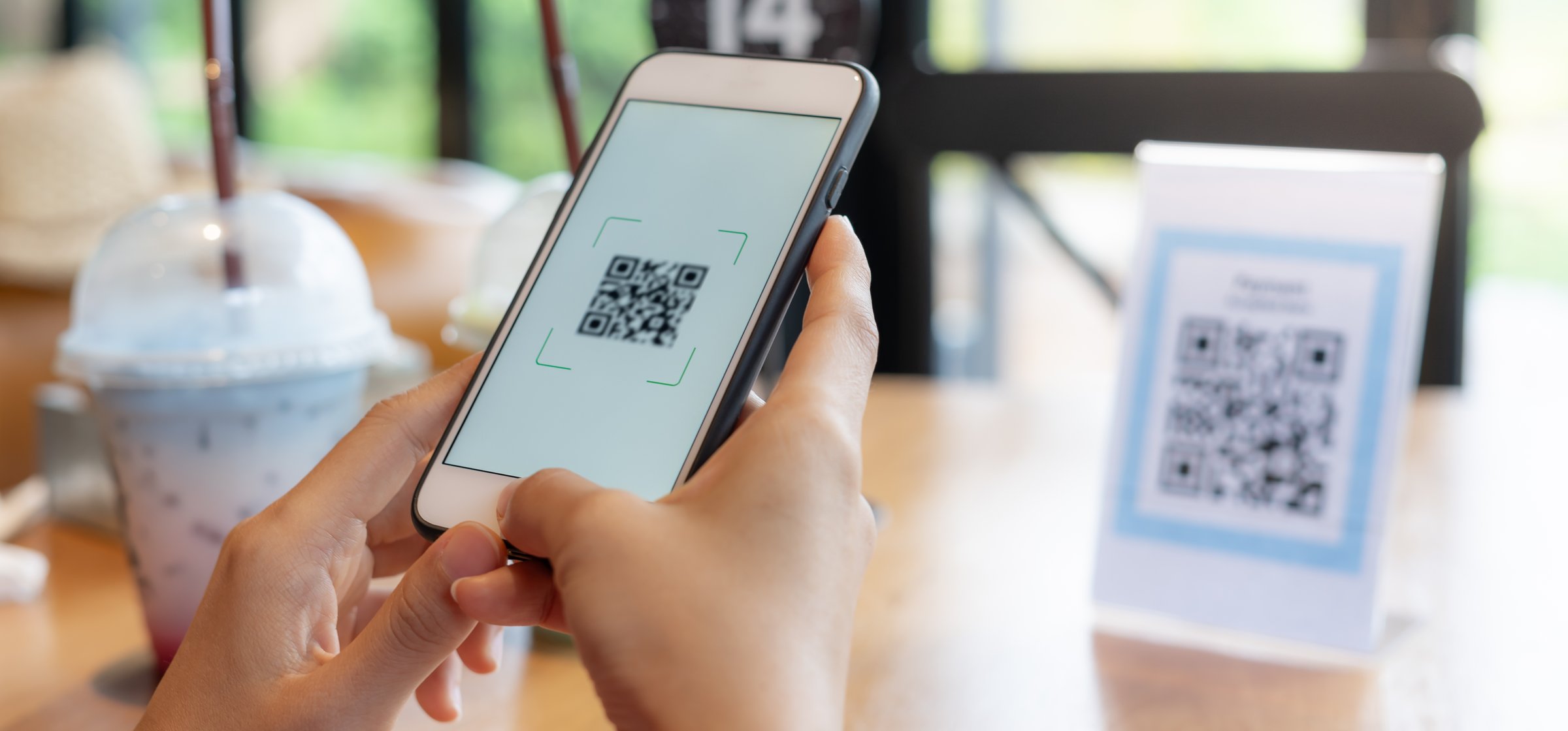 Woman use smartphone to scan QR code for order menu in cafe restaurant with a digital delivery