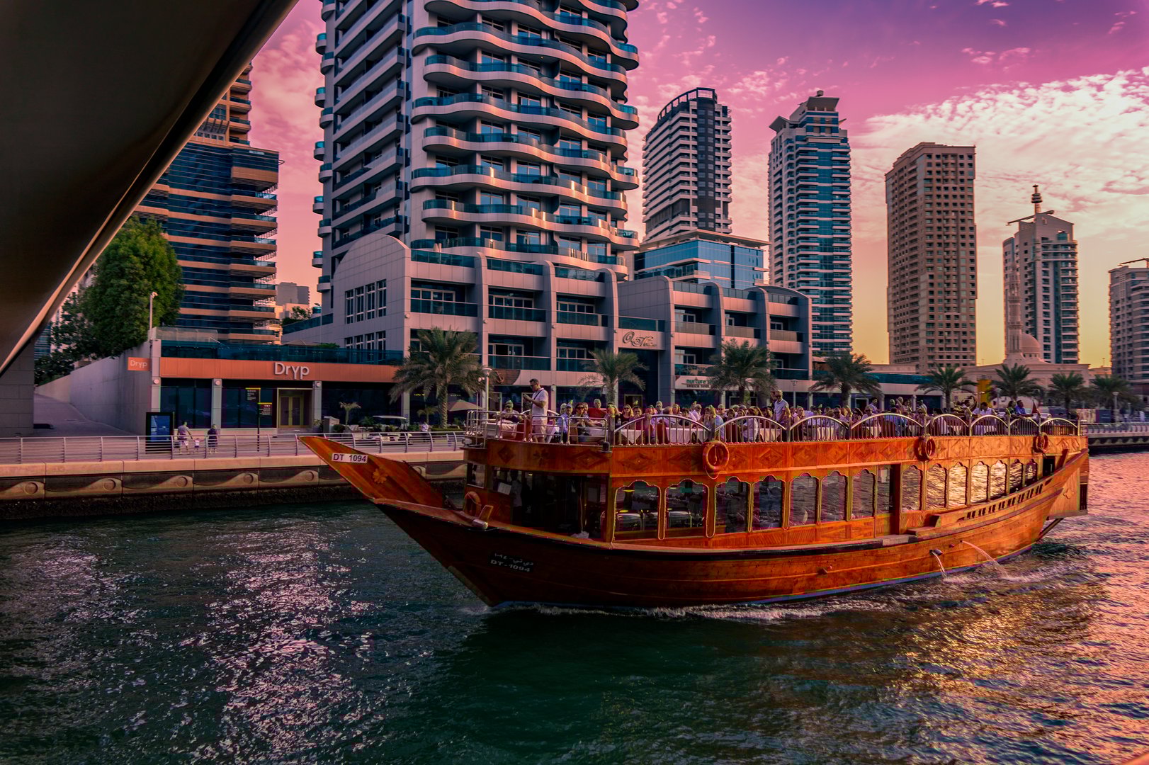 Dubai, UAE 11. 10. 2018 : Purple sunset on the Famous traditional wooden old dhow cruise tour in Dubai Marina