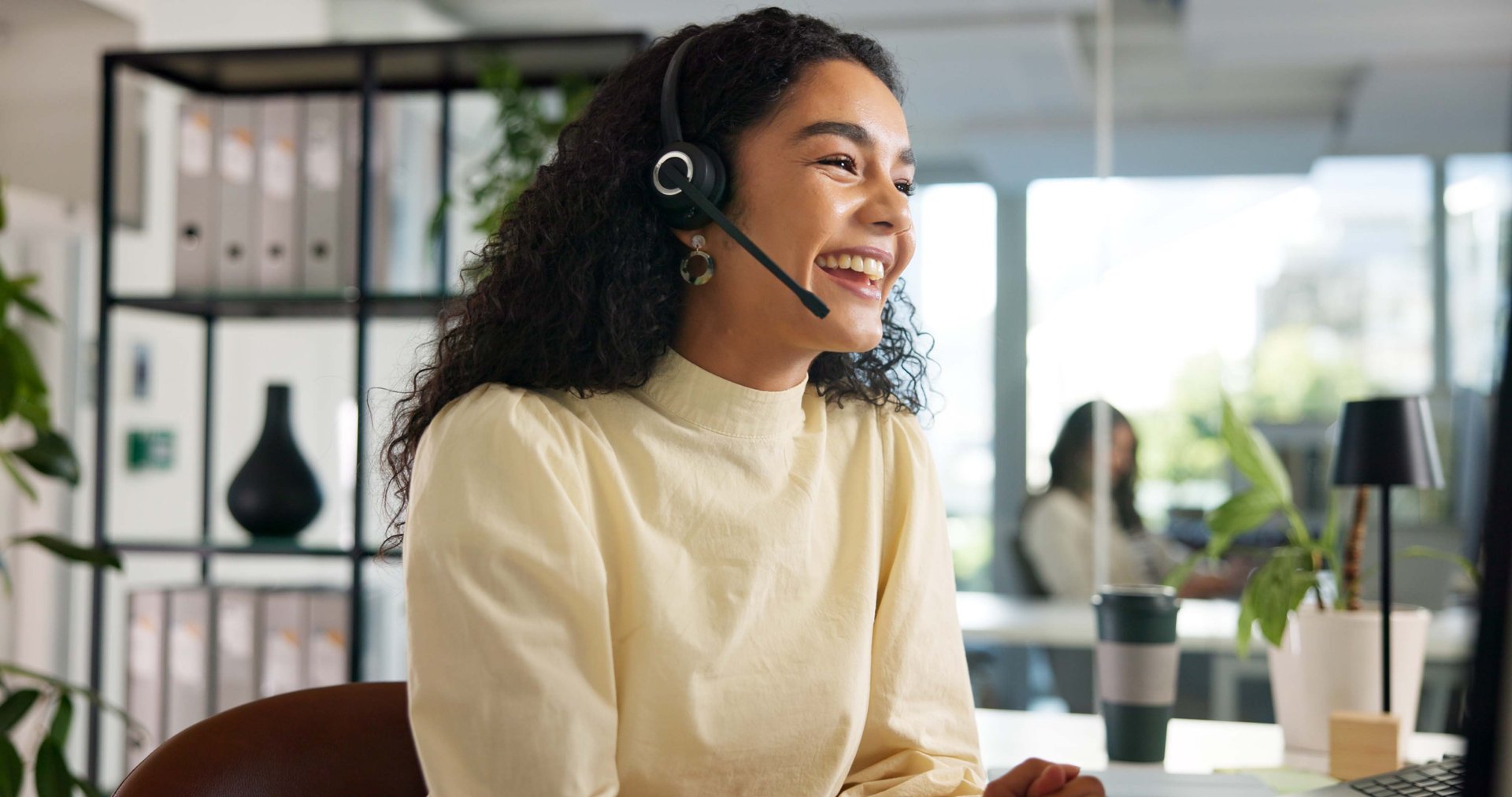Laughing, happy woman and customer service in call center with agent, communication and online consulting. Funny joke, friendly consultant and sales office for CRM contact support, advice or business