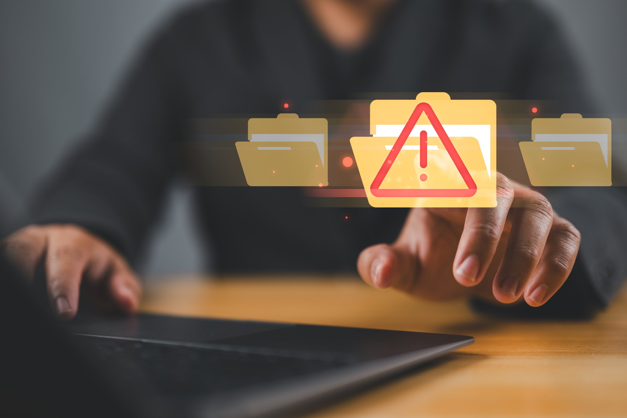 Cybersecurity alert with digital file folder. hand interacting with a cybersecurity alert symbol. virus, spyware, malicious software, malware, or cyberattacks on computer networks.