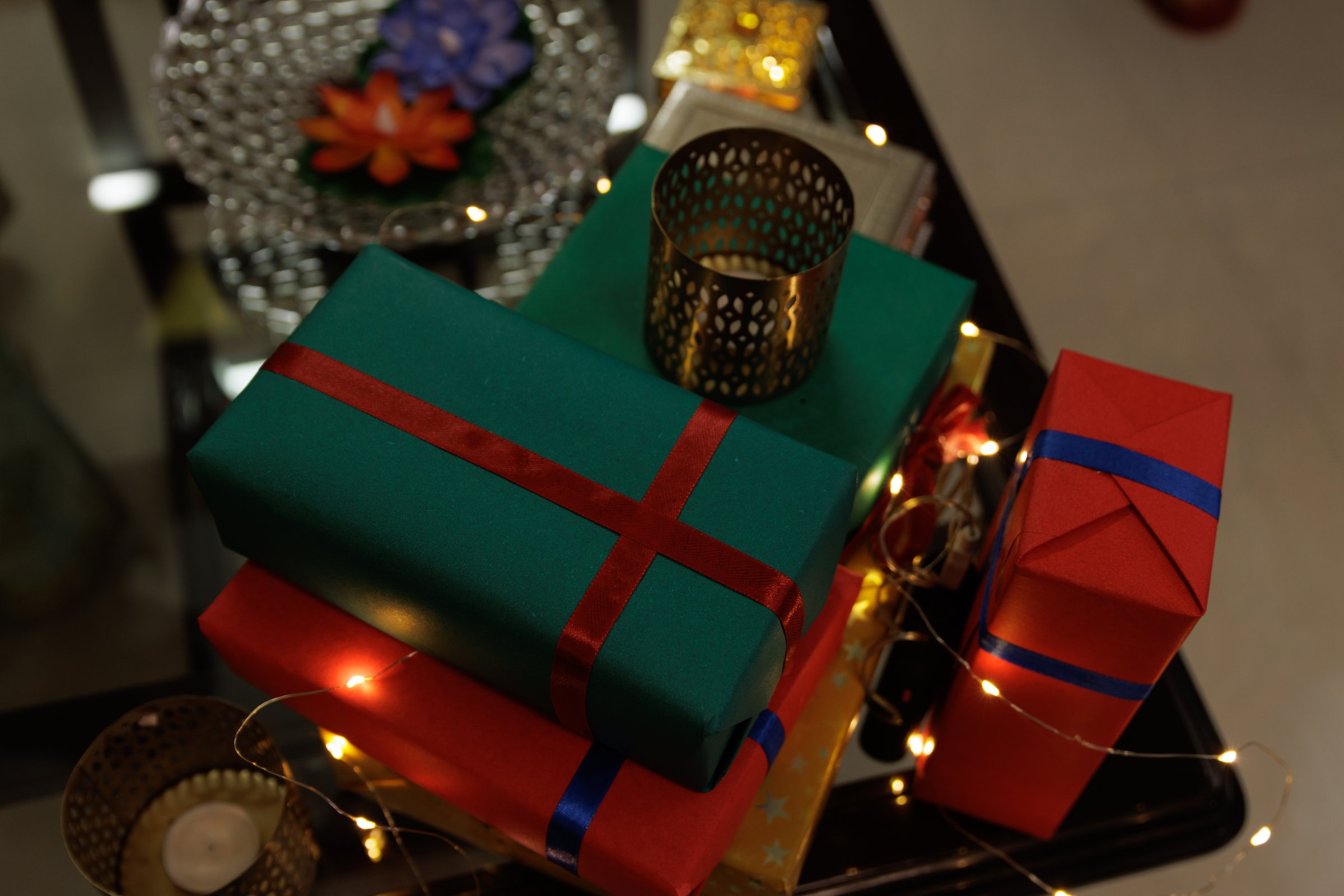 stack of gift boxes on glass table along with candles and sparkling light during Diwali, christmas, new year