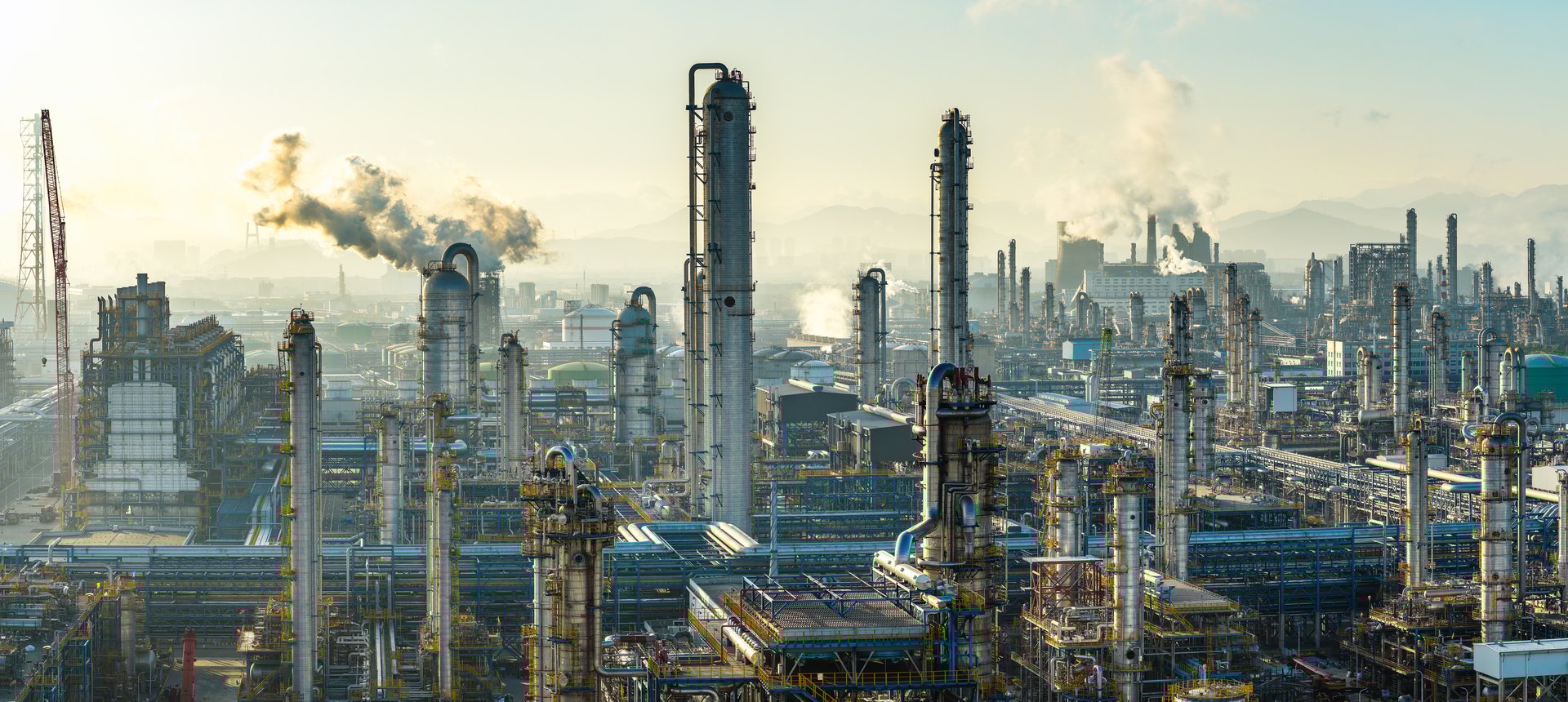 Aerial view of oil refinery and chemical plant with pipeline equipment in a large industrial area at sunrise