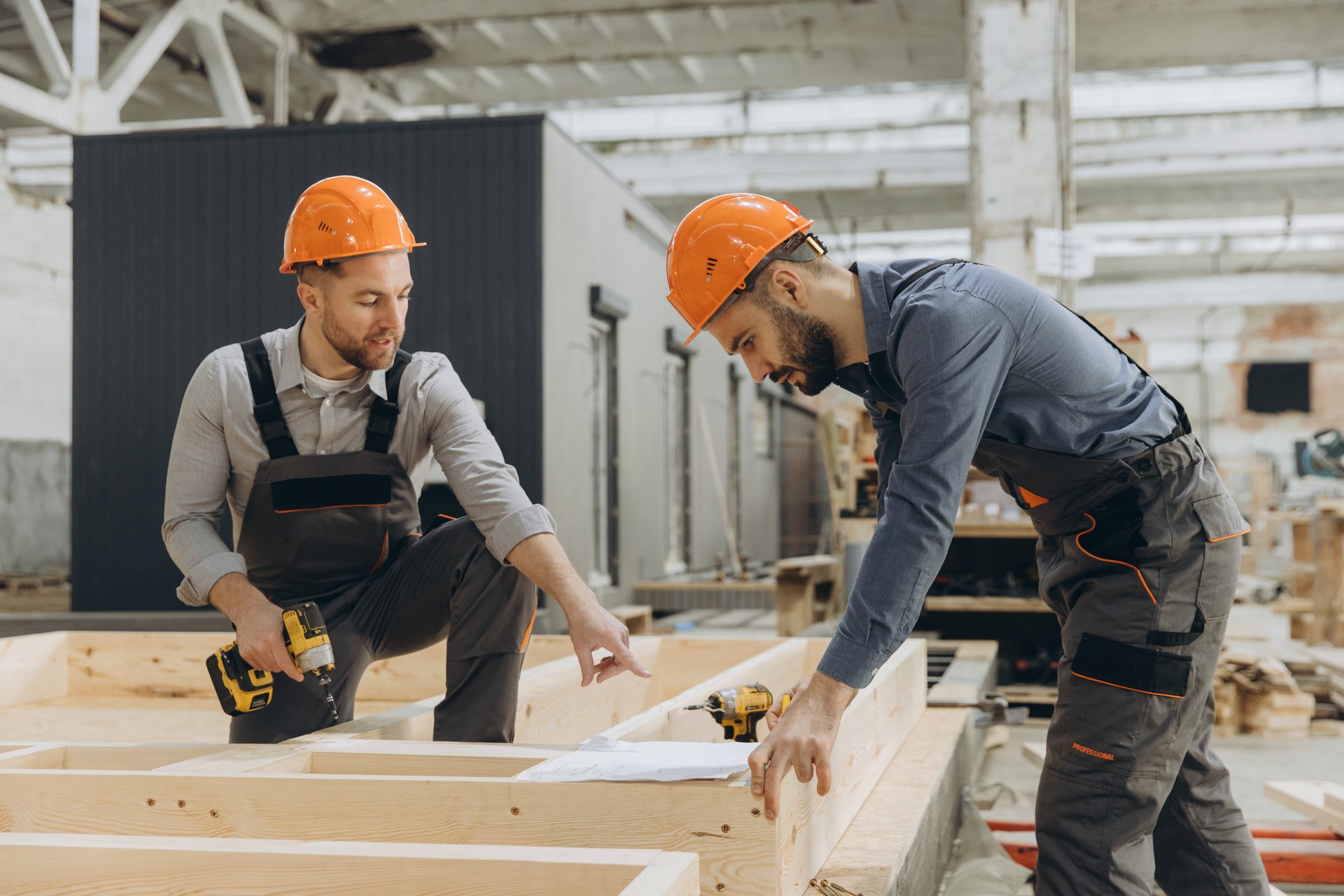 Two builders working on prefabricated house structure