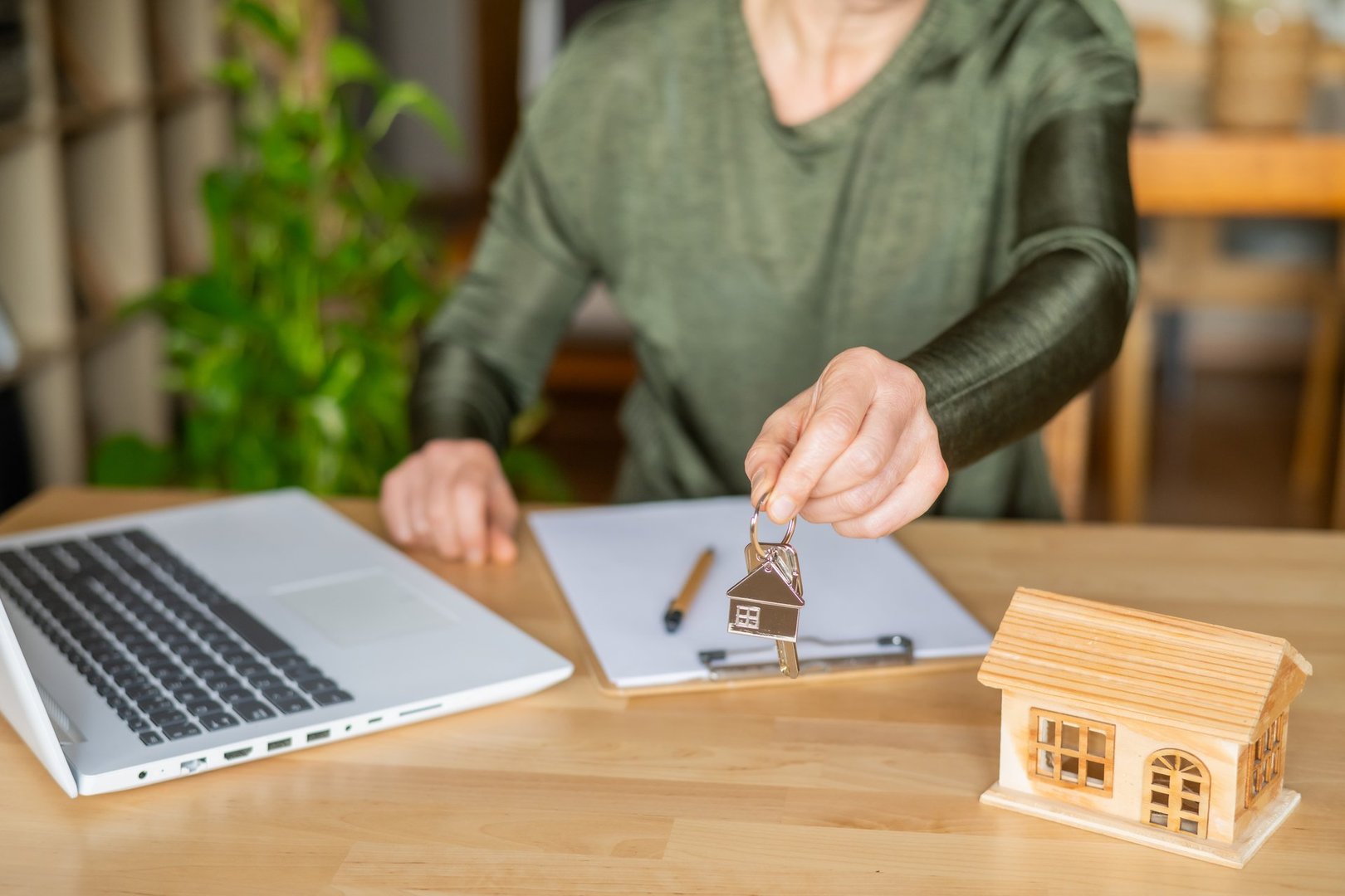 Clés de maison et ordinateur avec miniature bois - Transaction immobilière réussie au Québec 2026