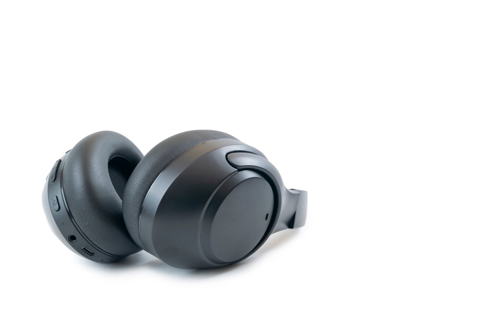 Professional black over ear wireless headphones with noise canceling feature isolated on white background.