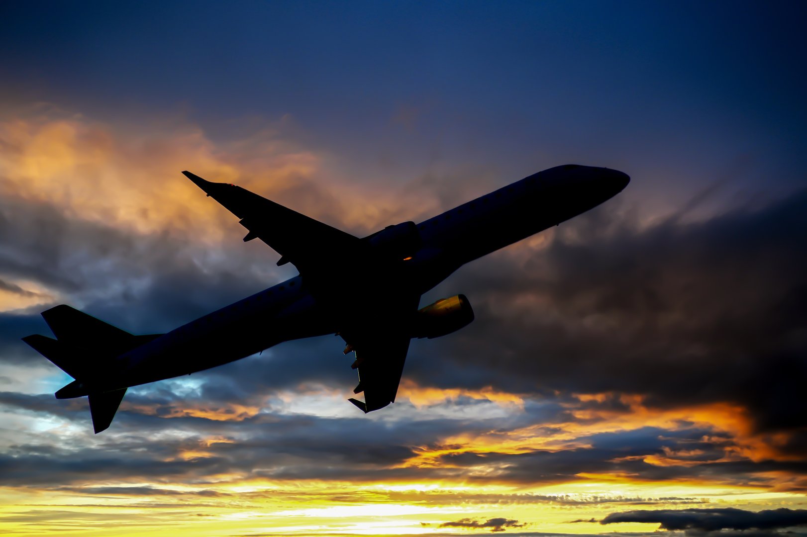 Airplane taking off at sunset
