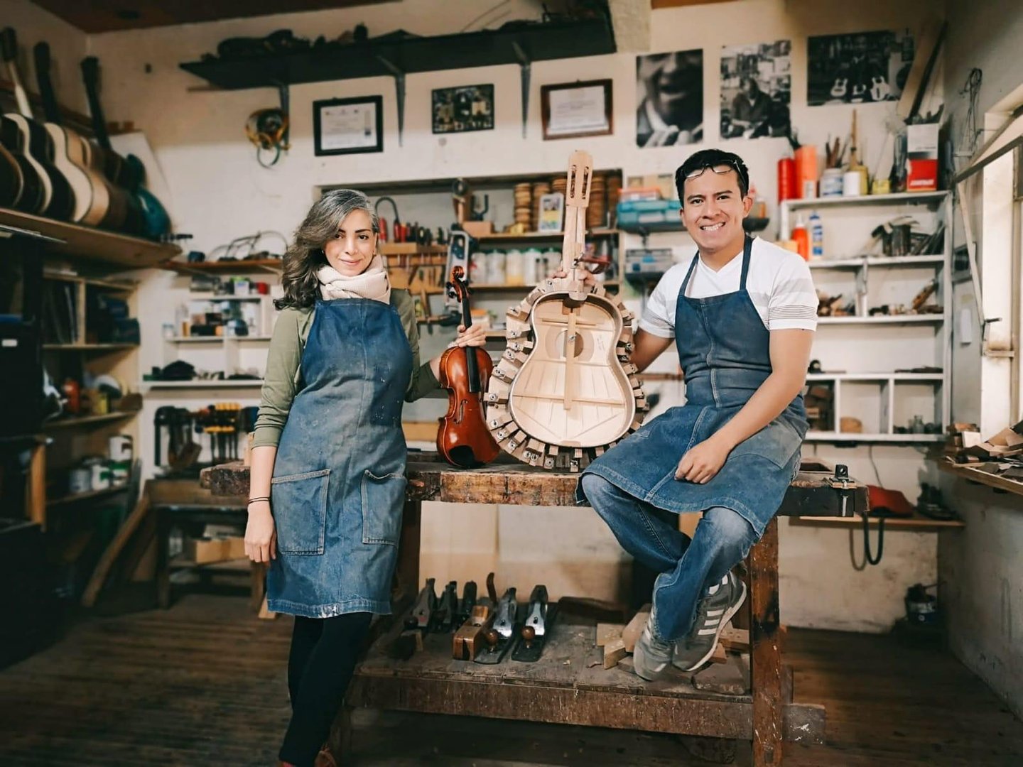 A back view of a violin maker working in a workshop