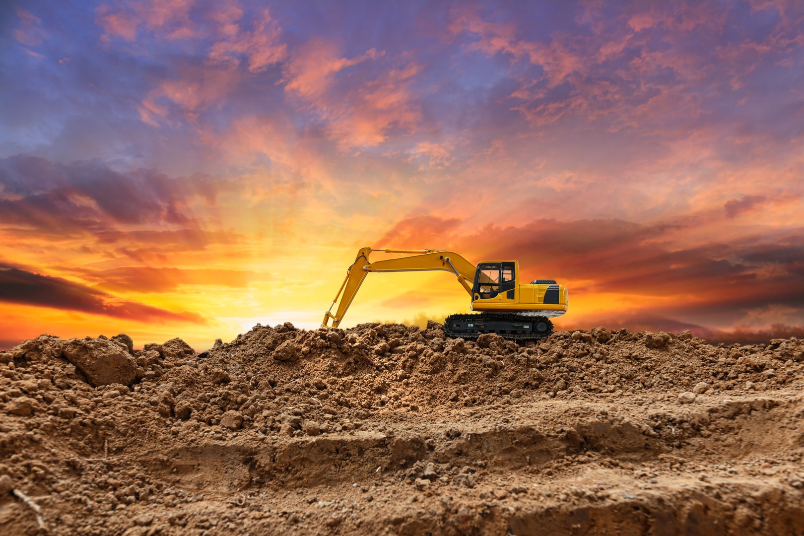 Crawler excavator with are digging the soil in the construction site on the sunset sky backgrounds