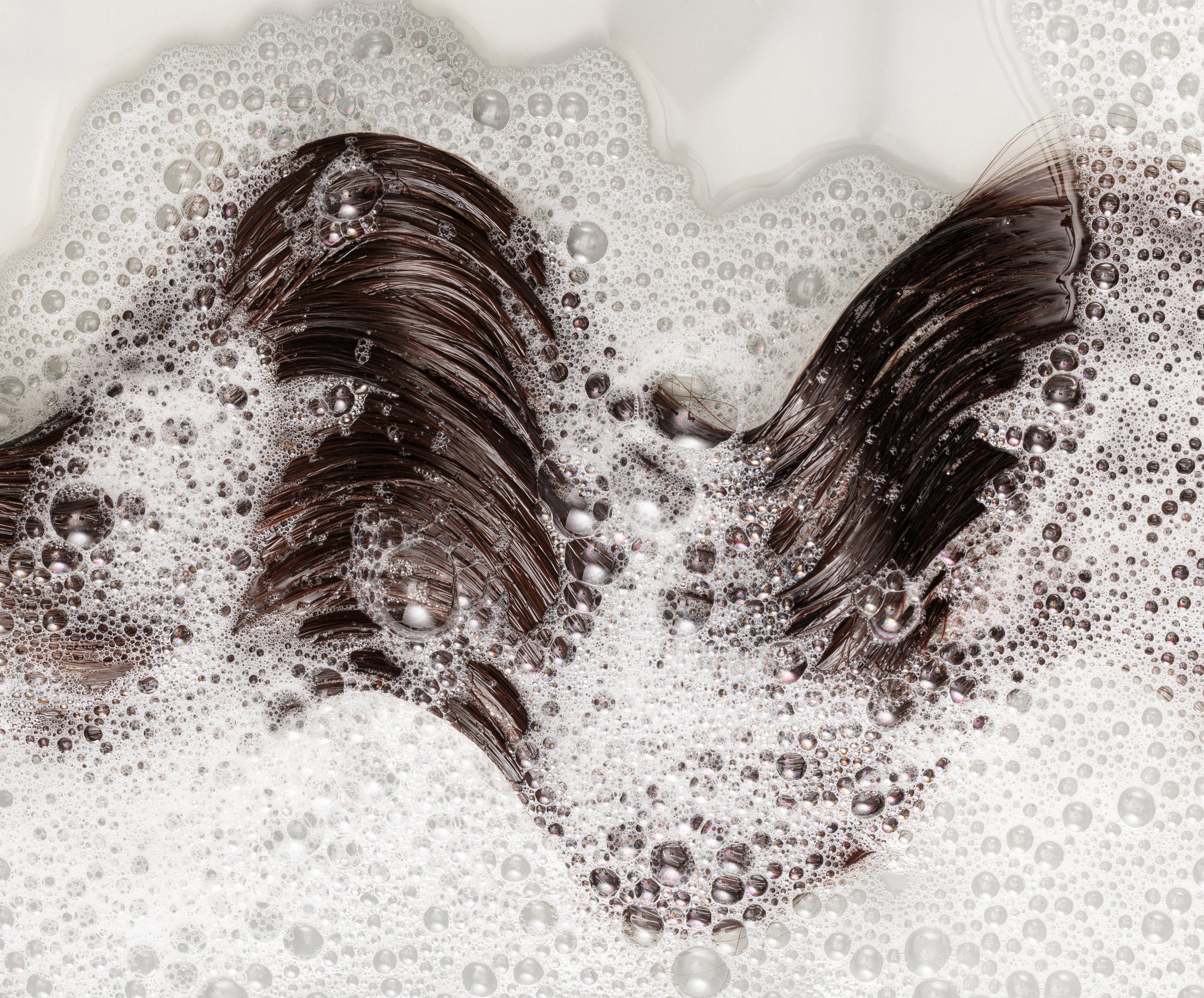washing the hair with shampoo, shampoo foam on dark brown hair
