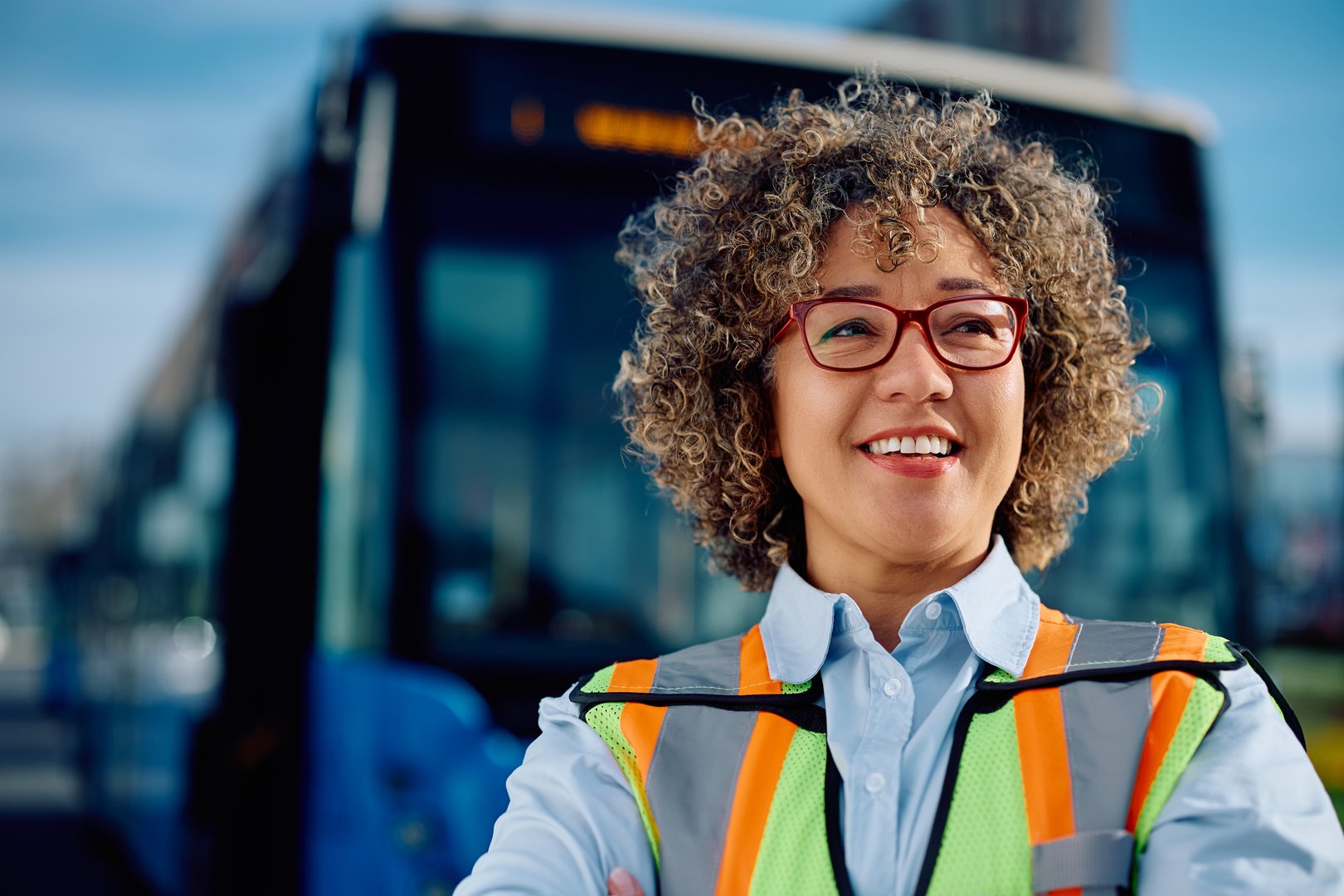 Happy woman working as public transport driver looking away.