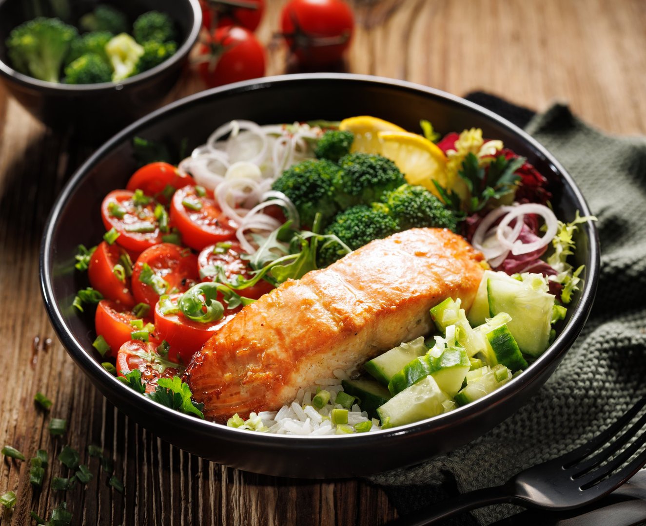 Close up of a salmon bowl with mix vegetables and rice, close-up. Healthy and delicious meal