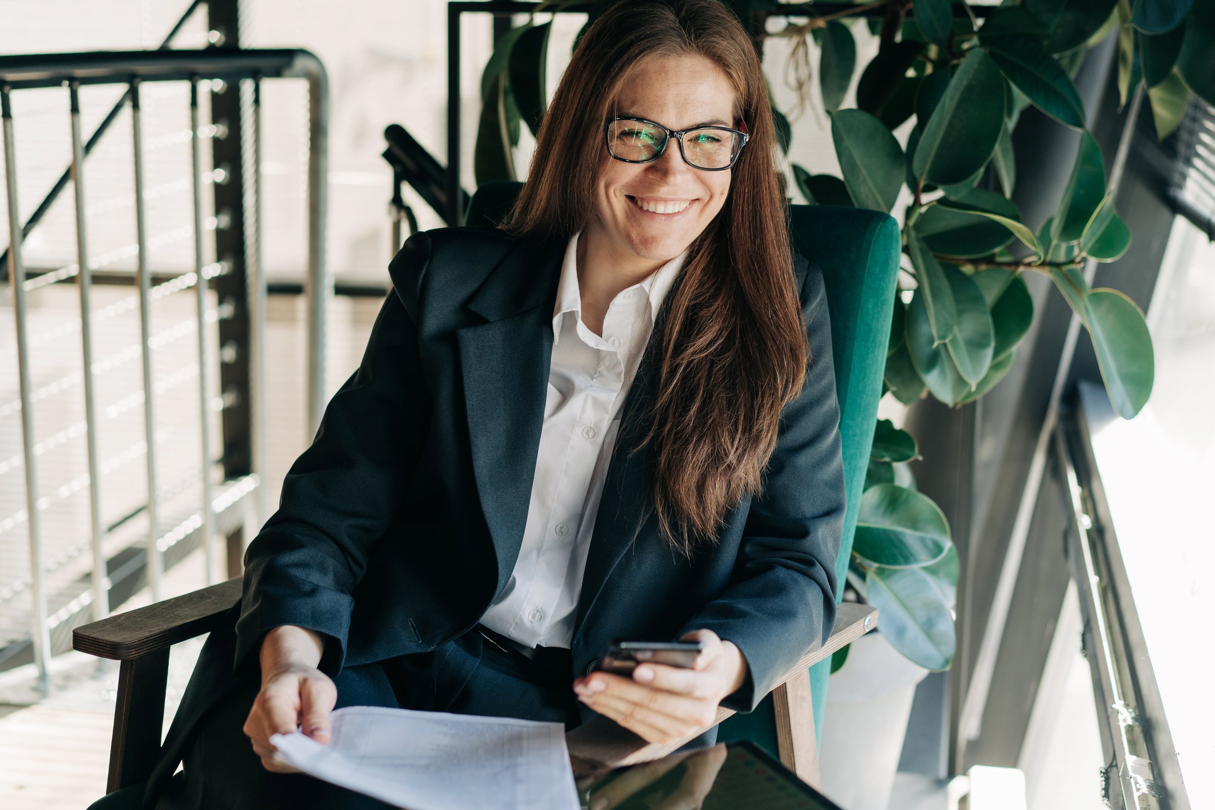 Portrait of a happy laughing business woman sitting at her workplace looking at the camera.