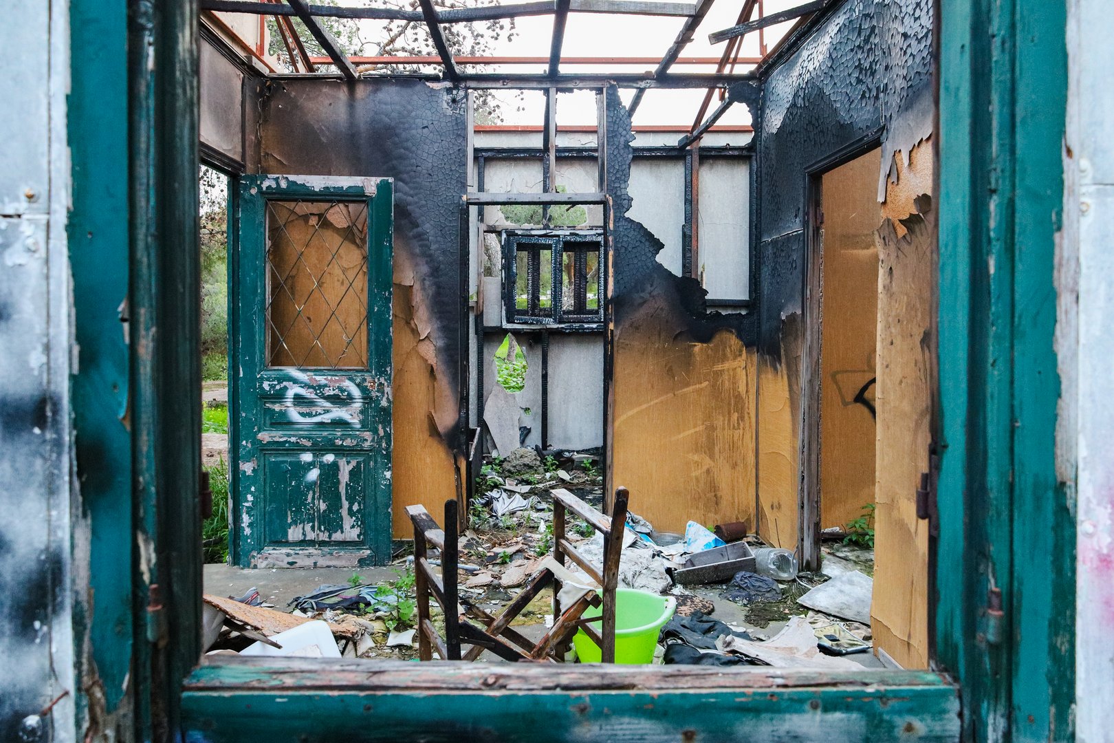Vouliagmeni, Greece - February 28, 2025. Burned, destroyed interior of an abandoned wooden house with Broken Furniture and Debris at Paragkes Beach, Vouliagmeni, Athens